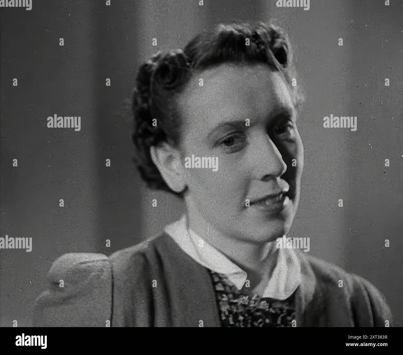 Eine Frau mit Haarschnitt im „Victory“-Stil, 1942. Großbritannien während des Zweiten Weltkriegs. Die "Victory"-Frisur für Frauen. Nicht so sehr ein Stil, sondern ein Abschneiden, um zu verhindern, dass die Schlösser in der Arbeit verfangen werden. Denn die Frauen, die "die Maschinen arbeiteten, die die Dinge herstellten, die den Krieg gewinnen wollten", hatten nicht viel Zeit für Schnickschnack. Aus „Time to Remember – The End of the Beginning“, 1942 (Reel 3); Dokumentarfilm über Ereignisse von 1942 und Amerikas Eintritt in den Krieg. Stockfoto