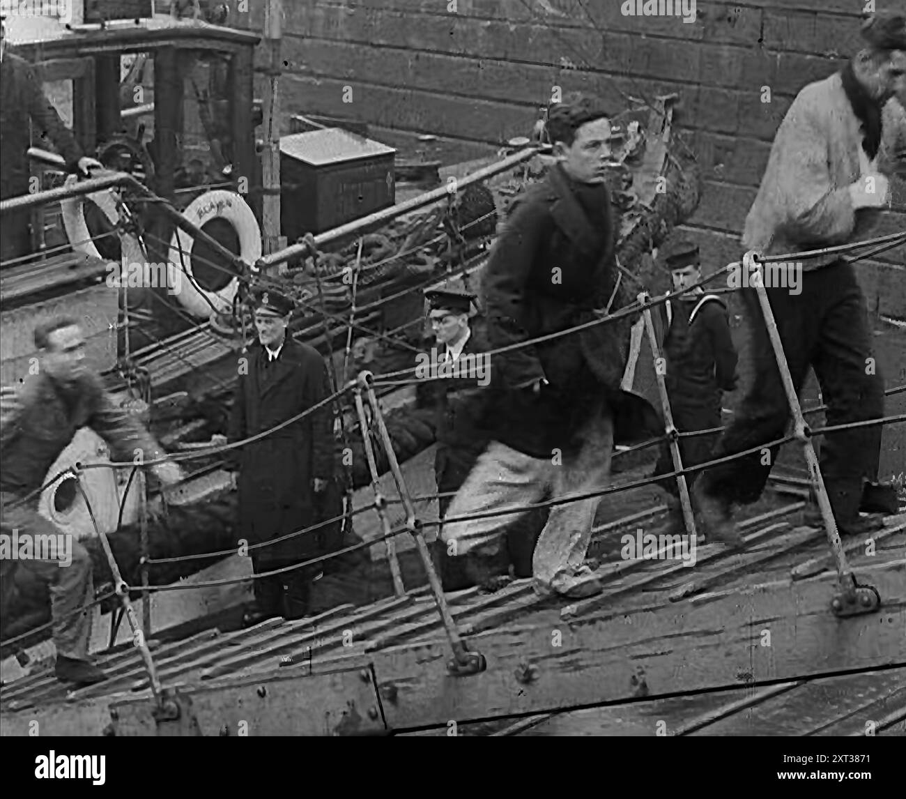 Besatzung der zerstörten Bismarck, die auf einer Gangplank in ein britisches Schiff lief, 1943. Aus Time to Remember - Struggle for A Planet, 1943 (Reel 3); Dokumentarfilm über Ereignisse von 1943, insbesondere die Schlacht am Atlantik. Stockfoto