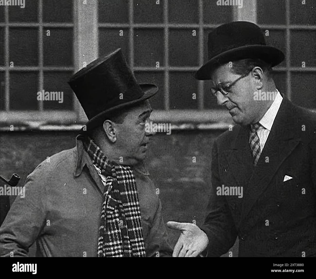 Syd Walker spricht mit Stanley Holloway über die Verwendung von Grammophon-Platten für war Materials, 1942. Großbritannien während des Zweiten Weltkriegs. „Eine Sache, um die wir gebeten wurden, war, alte Grammophon-Discs zu retten – nicht um Hitler zu Tode zu foltern, indem wir sie ihm vorspielen, sondern weil wir irgendeine Zutat oder andere [Schellack] retten, um ihm etwas zu helfen, das er ihm zuwerfen kann. Um diese alten Platten zu sammeln, ging Syd Walker mit einem barrow herum... [Stanley Holloway:] „Syd, nimm diese Platten auf - sie sind abgenutzt und nur für Schrott geeignet.“ "Blimey gefällt dir nicht Stanley Holloway." [Stanley:] „Nun Stockfoto