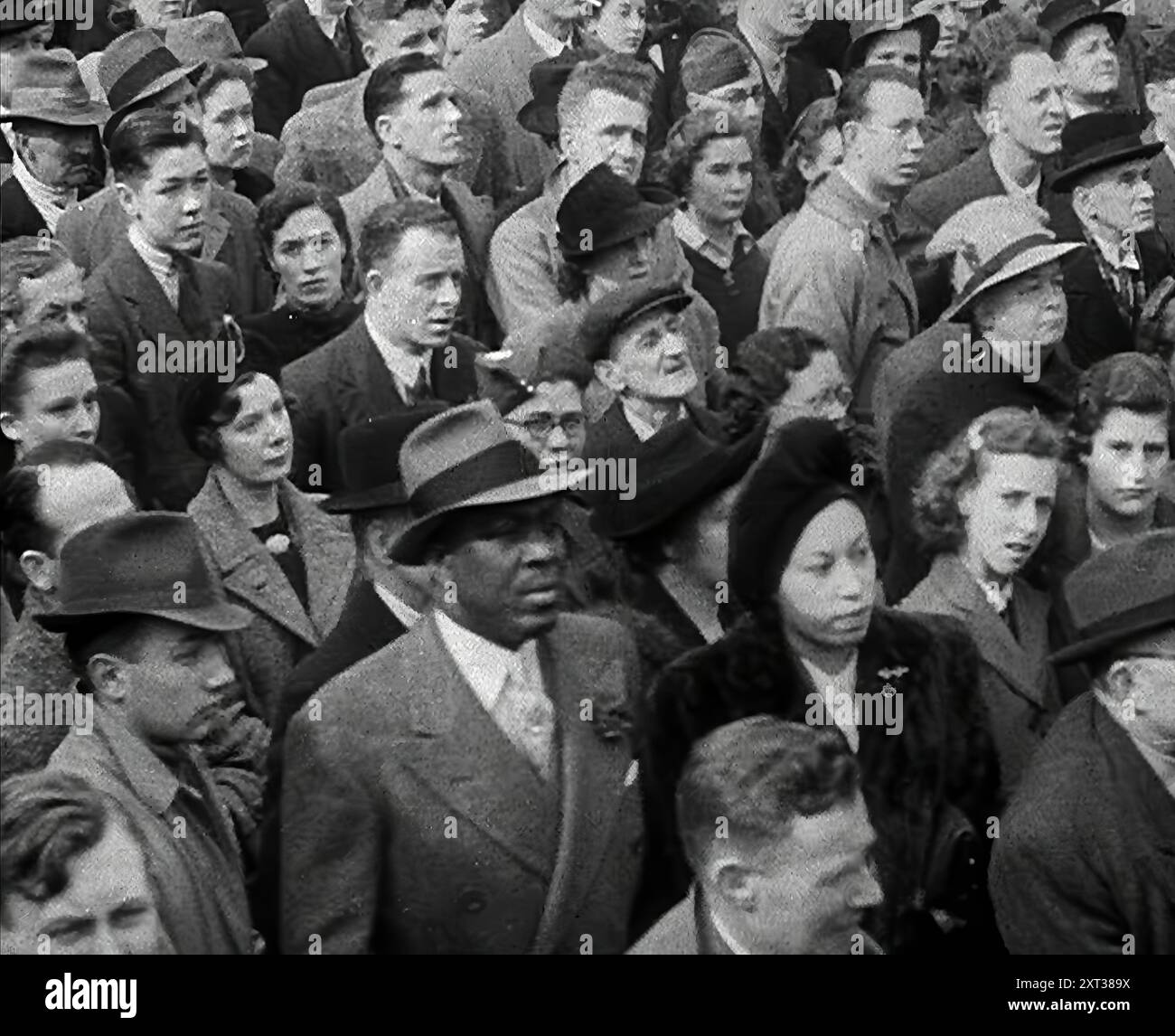 Massen hören Reden auf dem Trafalgar Square, 1942. Großbritannien während des Zweiten Weltkriegs. "Auf Londons Trafalgar Square"... ein leidenschaftliches Treffen mit Anzeichen für starke Gefühle von Millionen. Kämpfen Sie jetzt zurück und entlasten Sie das von der Belagerung betroffene Russland... vielleicht noch nie zuvor in der Geschichte der Welt haben so viele seiner Millionen in Entschlossenheit geeint. Für den Mann auf der Straße, für das Mädchen, das das Ding gemacht hat, das den Krieg gewinnen würde, Opfer, Knappheit und Wirtschaft. Aus „Time to Remember – The End of the Beginning“, 1942 ( Reel 2); Dokumentarfilm über die Ereignisse von 1942 und Stockfoto