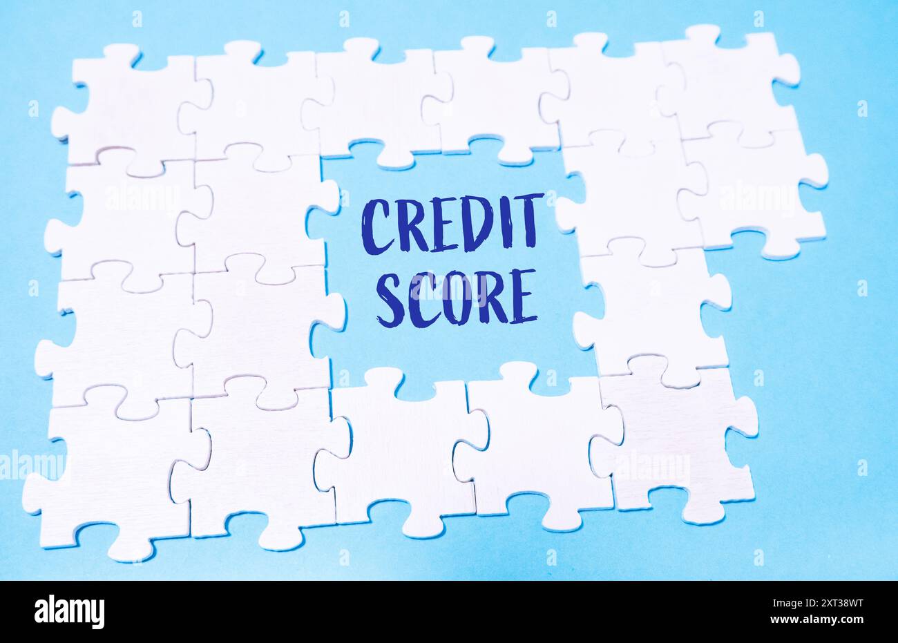 Ein Puzzle mit dem Wort "Credit Score" in der Mitte. Das Puzzle ist unvollständig, es fehlen Teile, und der blaue Hintergrund gibt einen Sinn Stockfoto