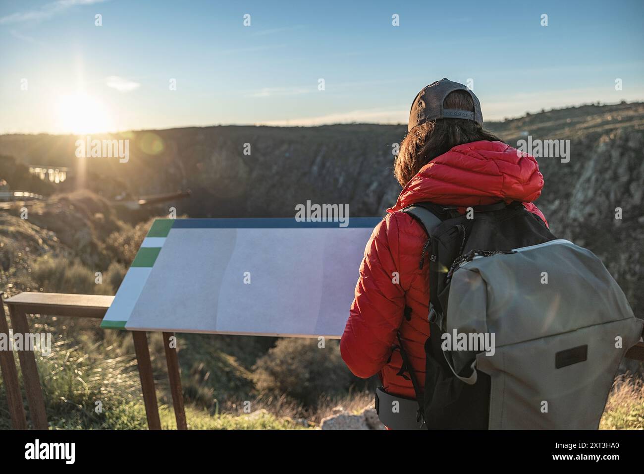 Rückansicht einer nicht erkennbaren, anonymen, gesichtslosen Frau, die während des Sonnenuntergangs an einem malerischen Aussichtspunkt in Salamanca, Spanien, Vogelbeobachtung betreibt. Sie Stockfoto