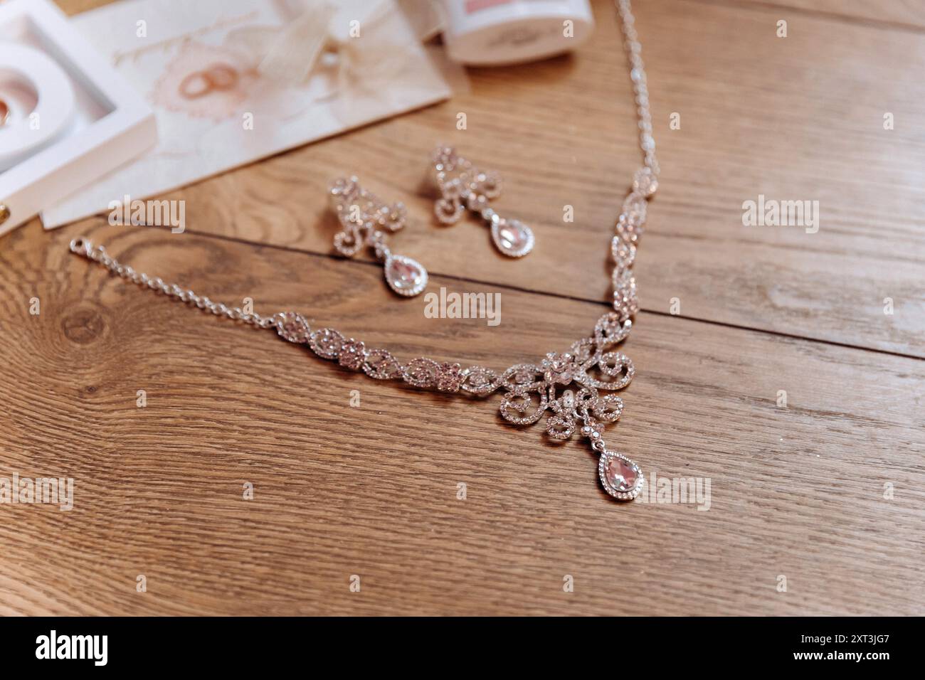 Brautjungfernkostüme: Absatzschuhe, Blumenstrauß, Ringe, Parfüm und Einladung auf dem Tisch Stockfoto