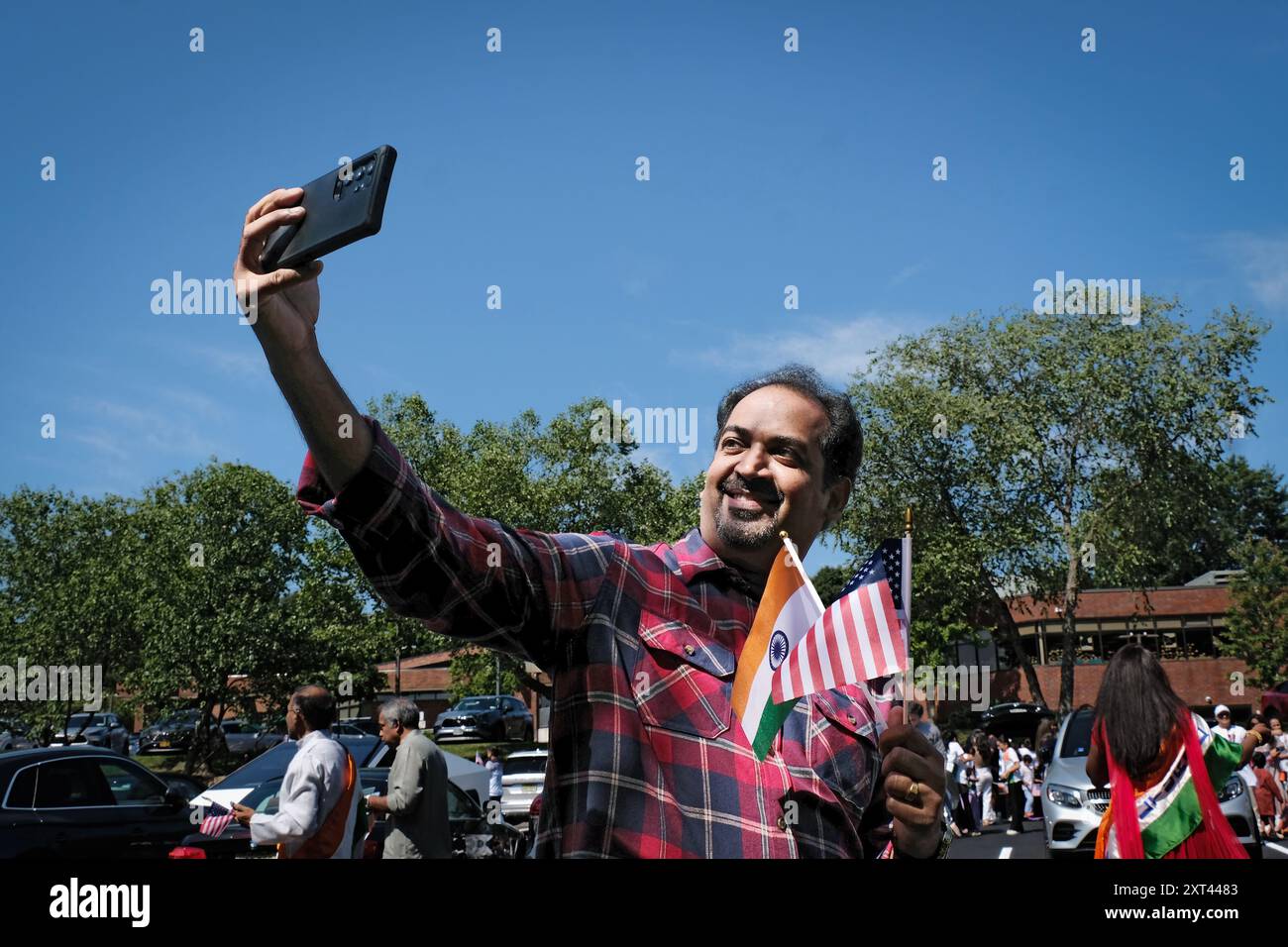 Ein hinduistischer Immigrant macht ein Selfie, das sowohl eine amerikanische als auch eine indische Flagge trägt. Bei der India Day Parade, die Indiens Unabhängigkeit feiert. In New City, NY. Stockfoto
