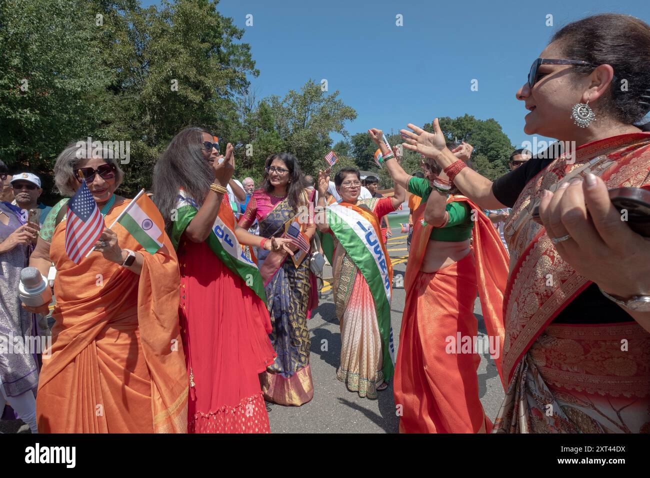 Fröhliche indianische Frauen schwenken Flaggen, während sie bei der Indianerparade marschieren, um die Unabhängigkeit des Landes zu feiern. In New City, Rockland County NY Stockfoto