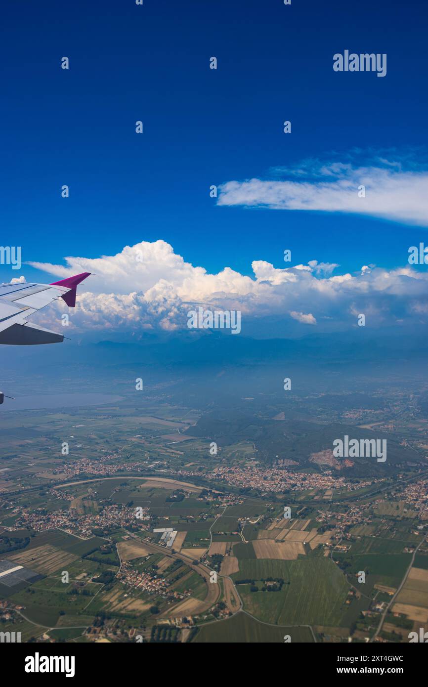 Luftaufnahme aus einem Flugzeugfenster. Flugzeugflügel und Stadtblick aus dem Flugzeug. Stockfoto
