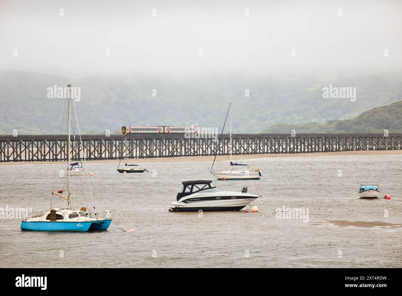 Barmouth Hafenboote haben auf dem Sand geerdet UND FAHREN ÜBER DIE BRÜCKE Stockfoto