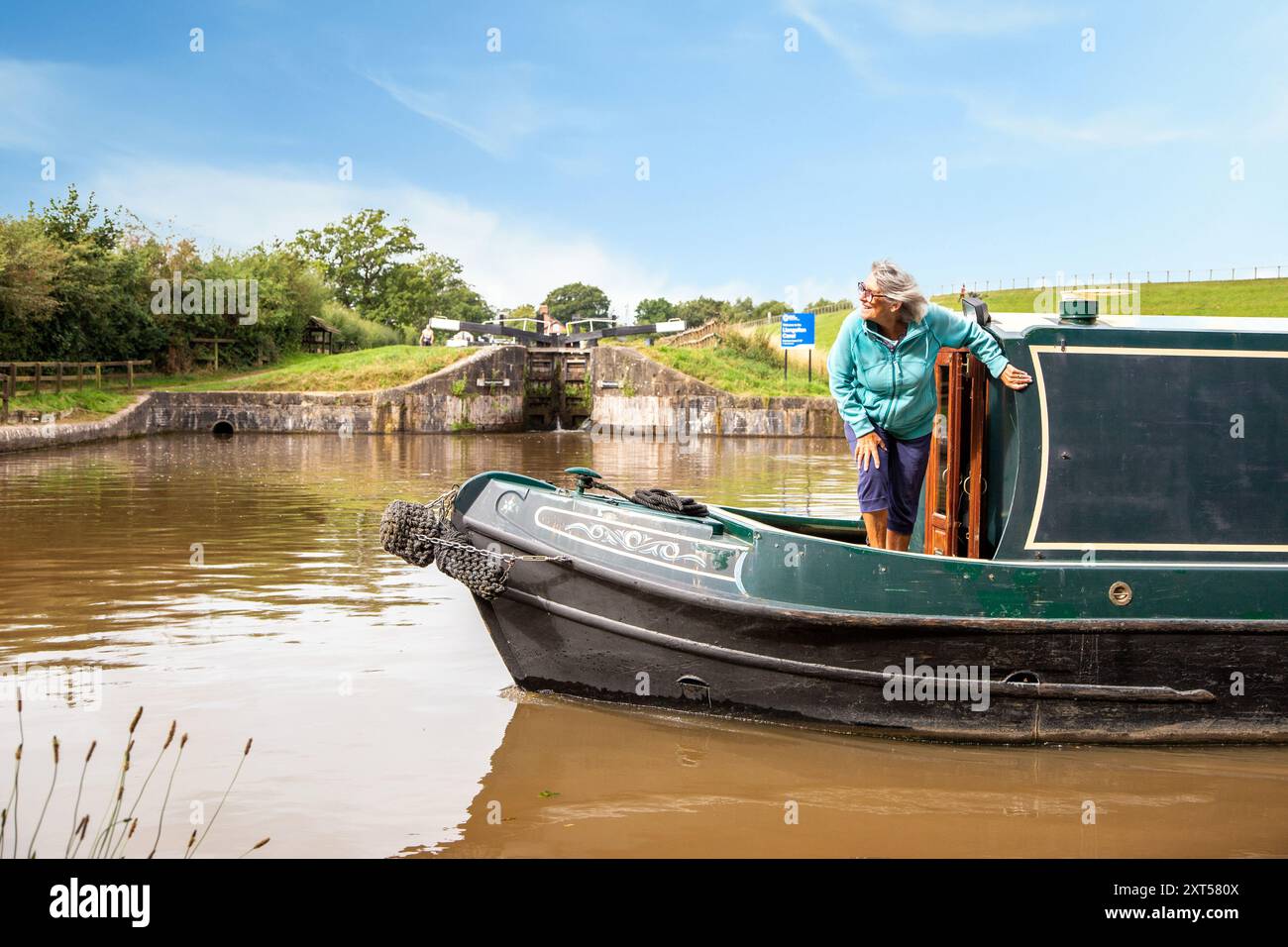Frau auf einem Kanalschmalboot, das die Hurleston-Kreuzung am Shropshire union Kanal Cheshire passiert Stockfoto