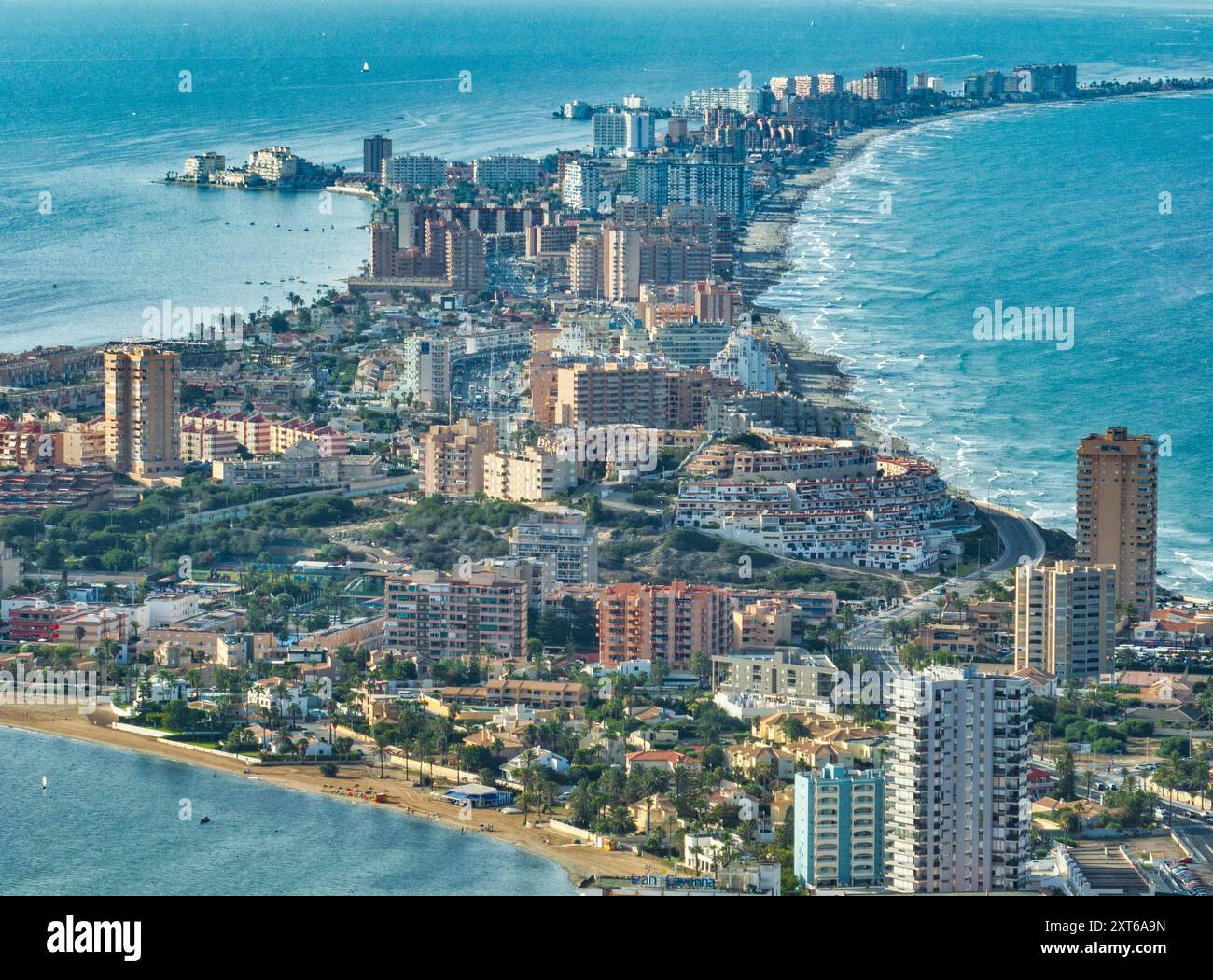 Blick aus der Vogelperspektive auf La Manga Seed von Mar Menor in der Region Murcia, Spanien, langer Streifen voller Hotels, Ferienhäuser beliebt für lokale Touristen Stockfoto