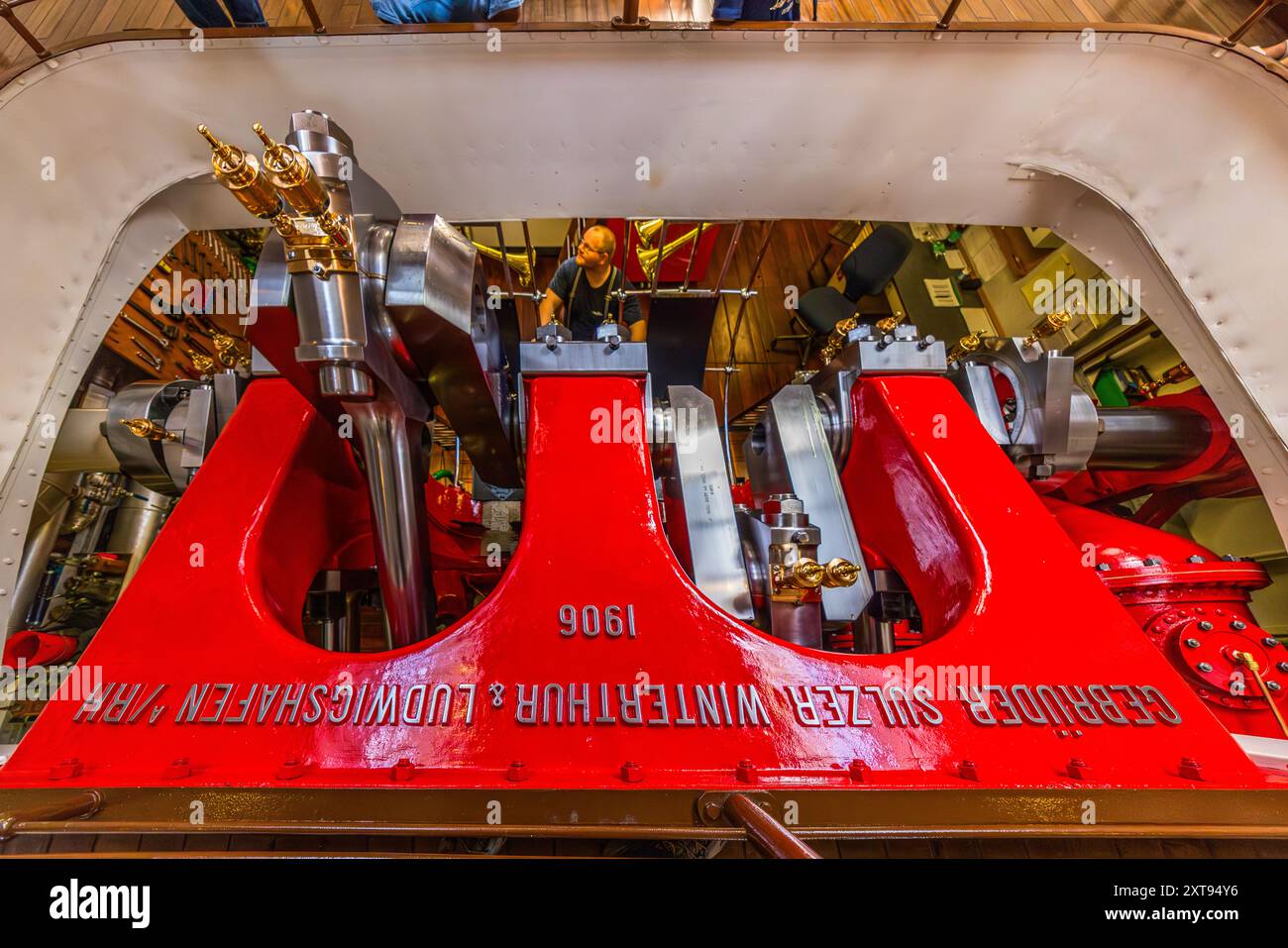 Auf den Raddampfern, die den Linienverkehr auf dem Vierwaldstättersee betreiben, sind die Dampfmaschine und der Ingenieur, der sie betreibt, für die Passagiere deutlich sichtbar. Seestraße, Gersau, Schwyz, Schweiz Stockfoto