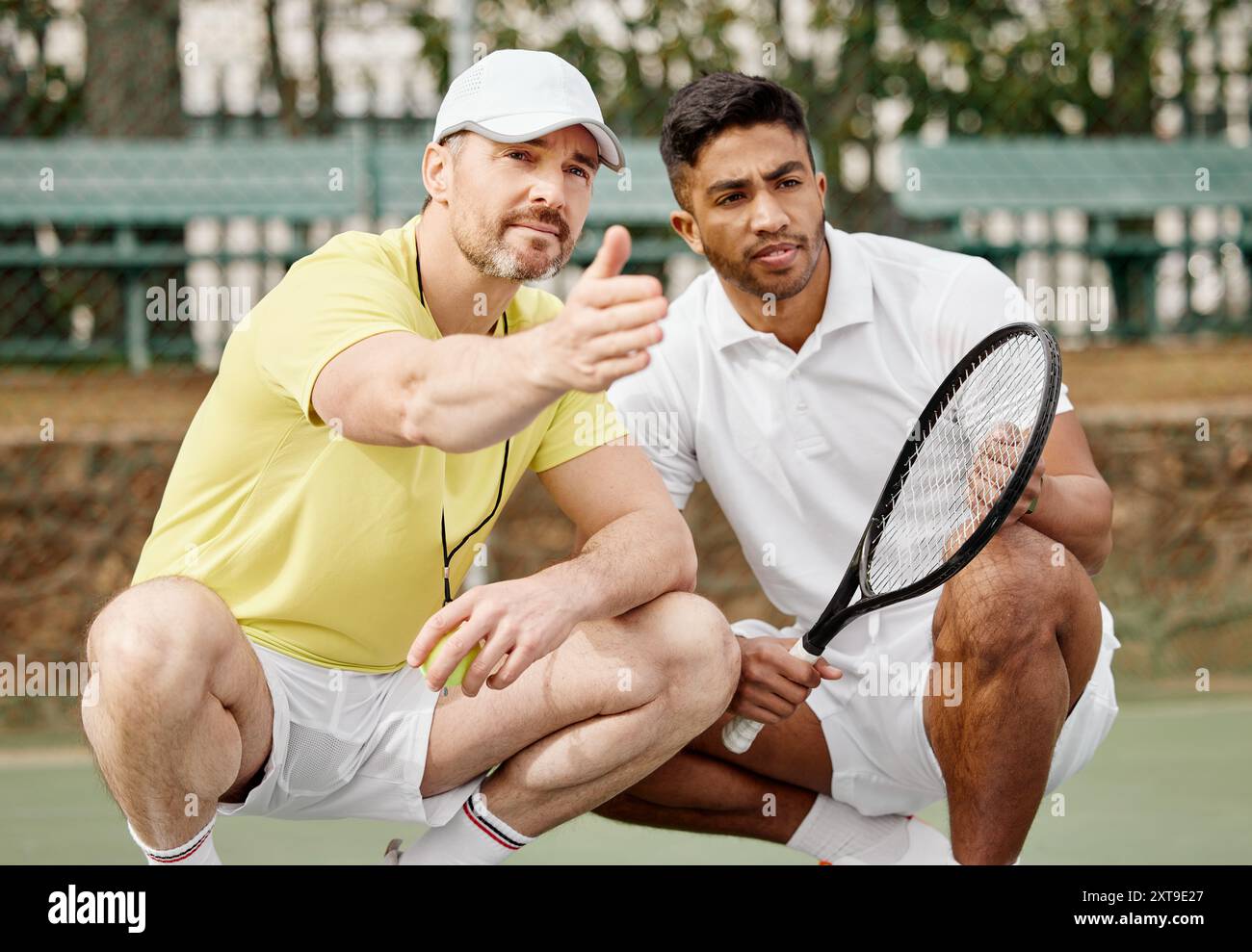 Tennisspieler, Trainer und Gespräch mit Mann auf dem Platz mit Spielstrategie, Spielanweisungen oder Spielplanung. Sport, Mentor und Sportler mit Zeigen Stockfoto