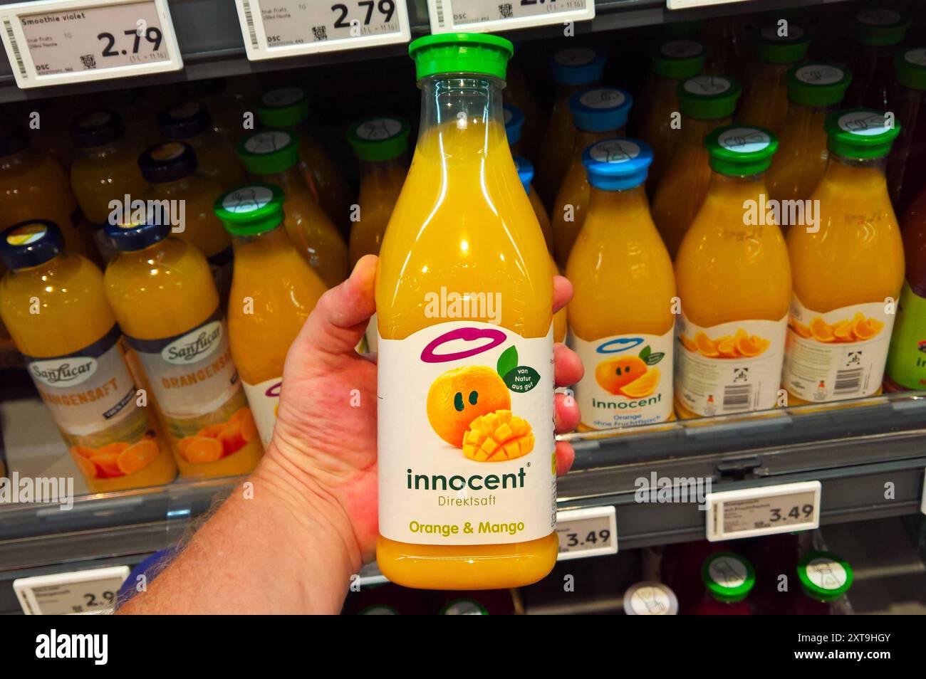 Innocent Limited ist ein Unternehmen aus Grossbritannien, das sich auf die Herstellung von Smoothies und Fruchtsäften spezialisiert hat. Im Jahr 2009 erwarb Coca-Cola zunächst einen Minderheitsanteil unterhalb der Sperrminorität. Seit 2013 besitzt Coca-Cola über 90 Prozent der Unternehmensanteile. Foto: Innocent Saft bzw Direktsaft, Orange und Mango im Supermarkt-Regal *** Innocent Limited ist ein in Großbritannien ansässiges Unternehmen, das sich auf die Herstellung von Smoothies und Fruchtsäften spezialisiert hat 2009 erwarb Coca Cola zunächst eine Minderheitsbeteiligung unterhalb der Sperrminorität seit 2013 besitzt Coca Cola mehr als 90 Prozent Stockfoto