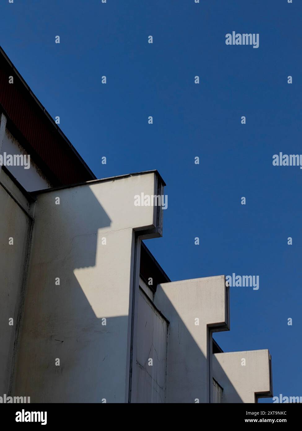 Abstraktes Gesicht des Dachs: Erkunden von Licht, Schatten, Muster und Textur in der Gebäudearchitektur. Stockfoto