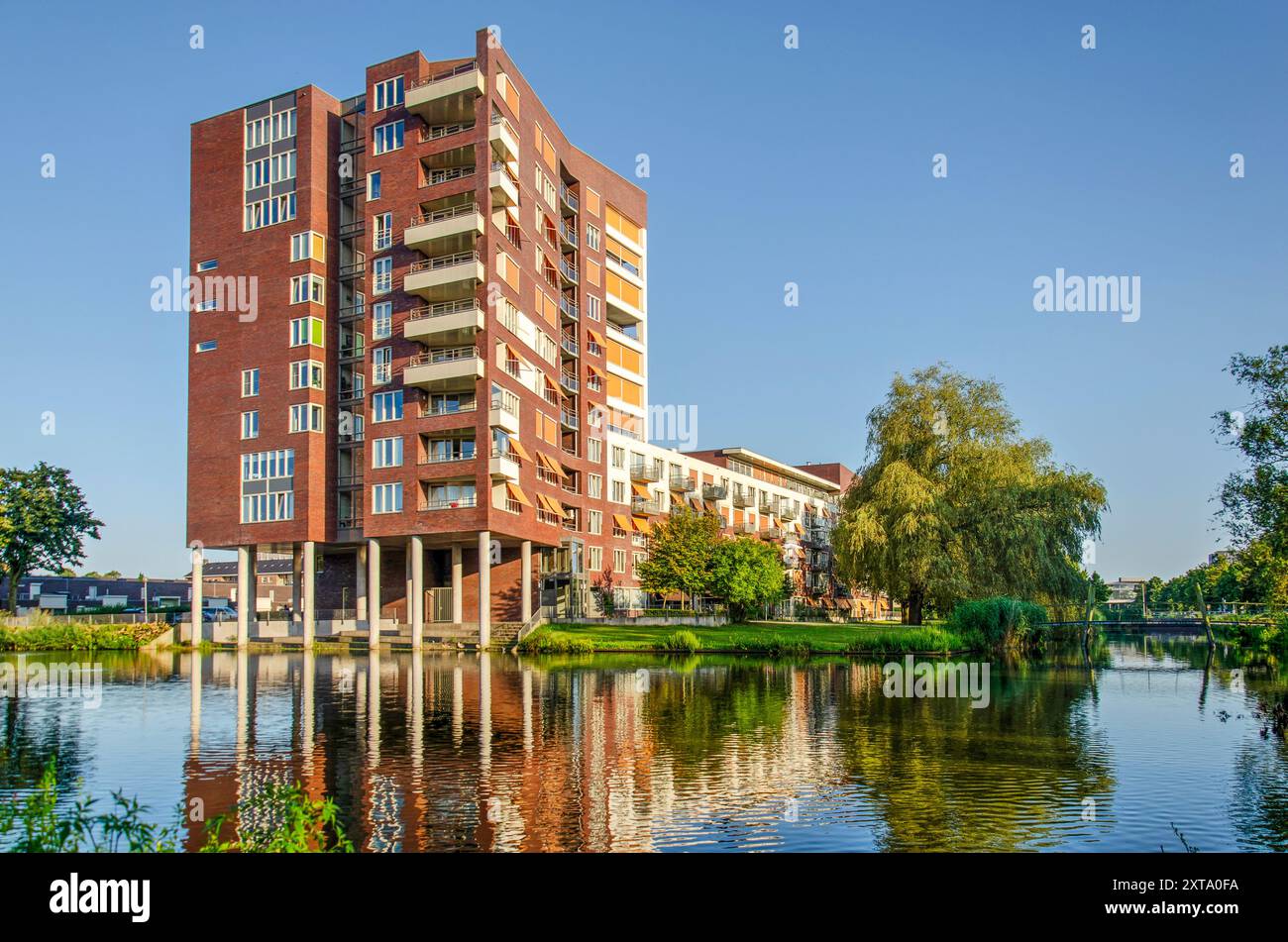 Zwolle, 5. August 2024: Pflegeheim aus den 1990er Jahren reflektiert im angrenzenden Teich während der goldenen Stunde an einem Sommerabend Stockfoto