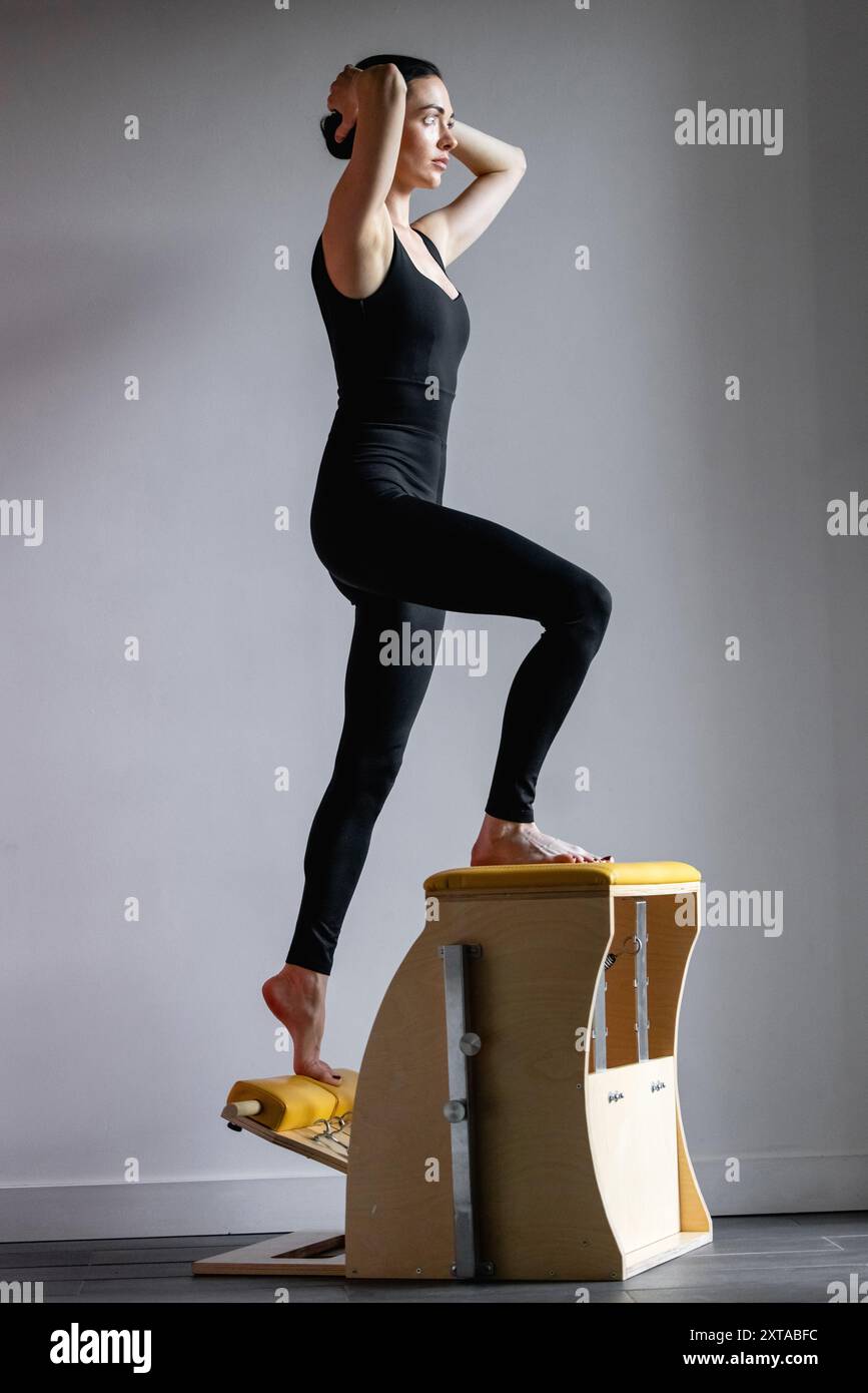 Pilates Reformer Stuhl Frau Fitness Yoga Gym Übung. Korrektur des Körpers des Bewegungsapparates. Stockfoto