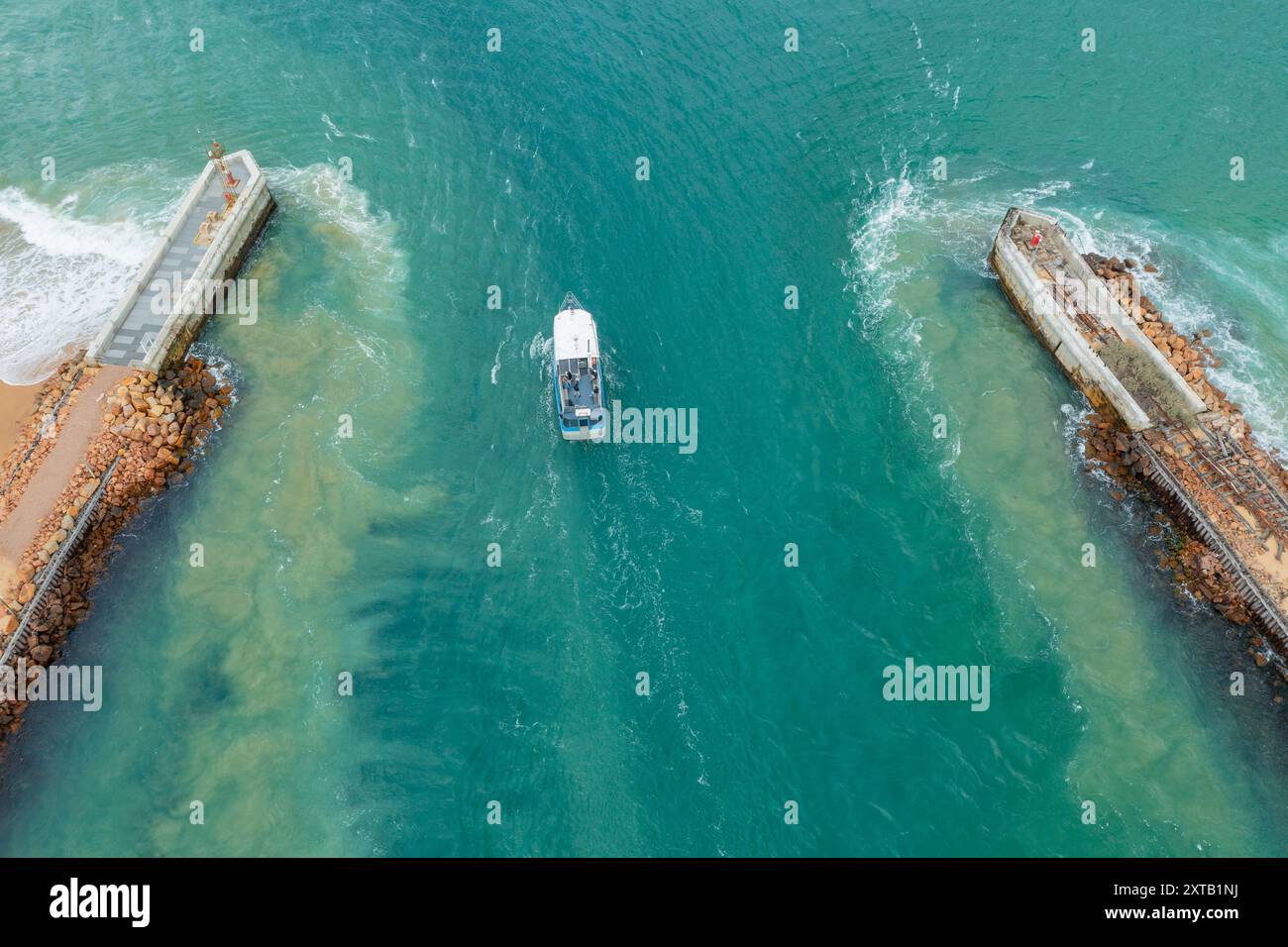 Aus der Vogelperspektive eines kleinen Bootes in einer Flussmündung zwischen zwei Mauer am Lakes Entrance in Gippsland, Victoria, Australien. Stockfoto