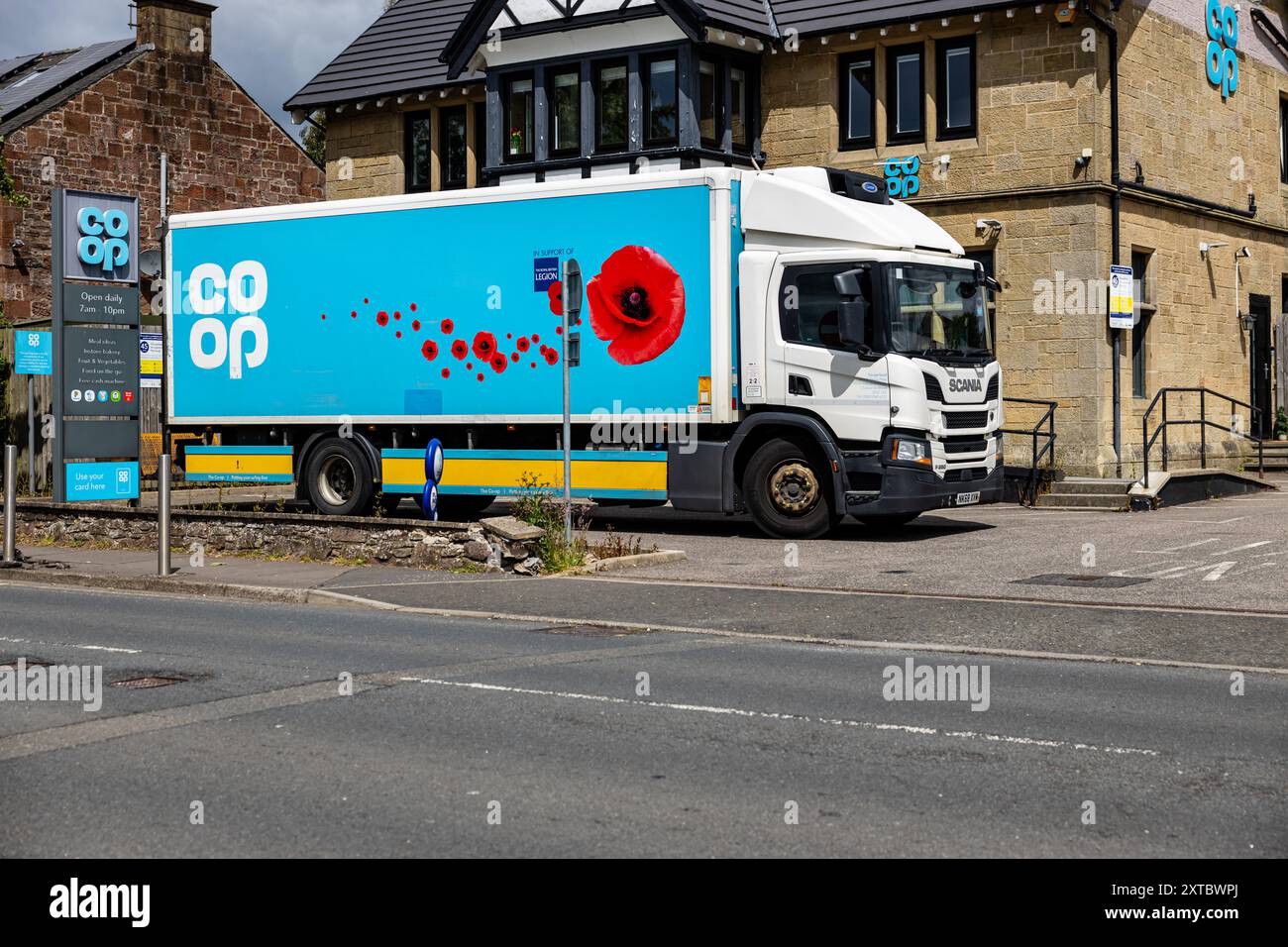 Blauer Koop-Lieferwagen, der vor dem Koop-Dorf-Laden geparkt wurde, ein umgebautes Wirtshaus, mit COOP-Schild und Ladenschildern im Blick, aber keine Leute Stockfoto