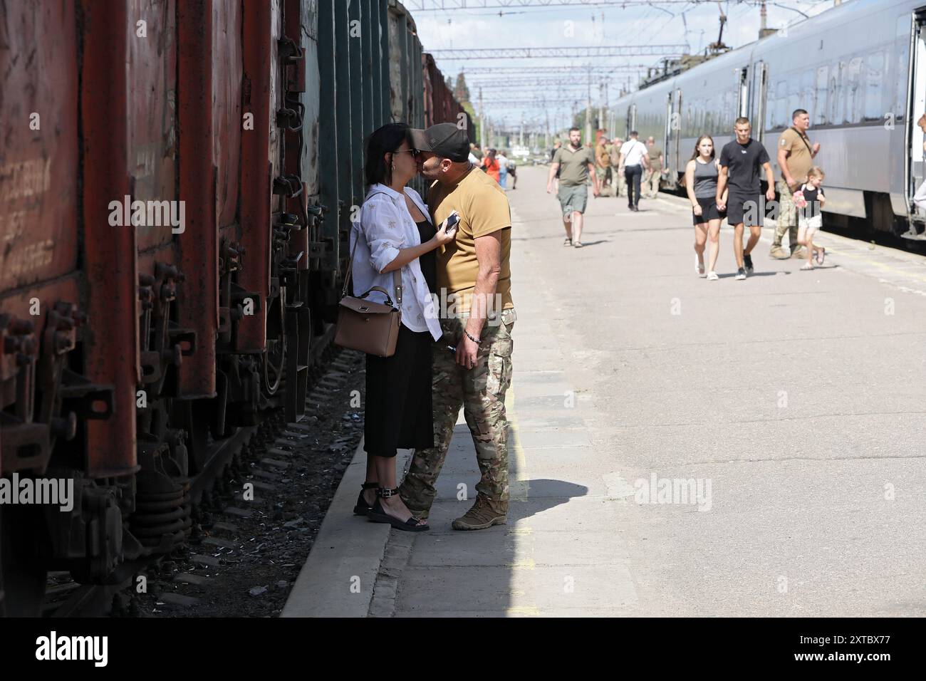 Nicht exklusiv: KRAMATORSK, UKRAINE - 12. AUGUST 2024 - Ein ukrainischer Soldat küsst seinen Partner, während er sich auf einem Bahnsteig verabschiedet Stockfoto