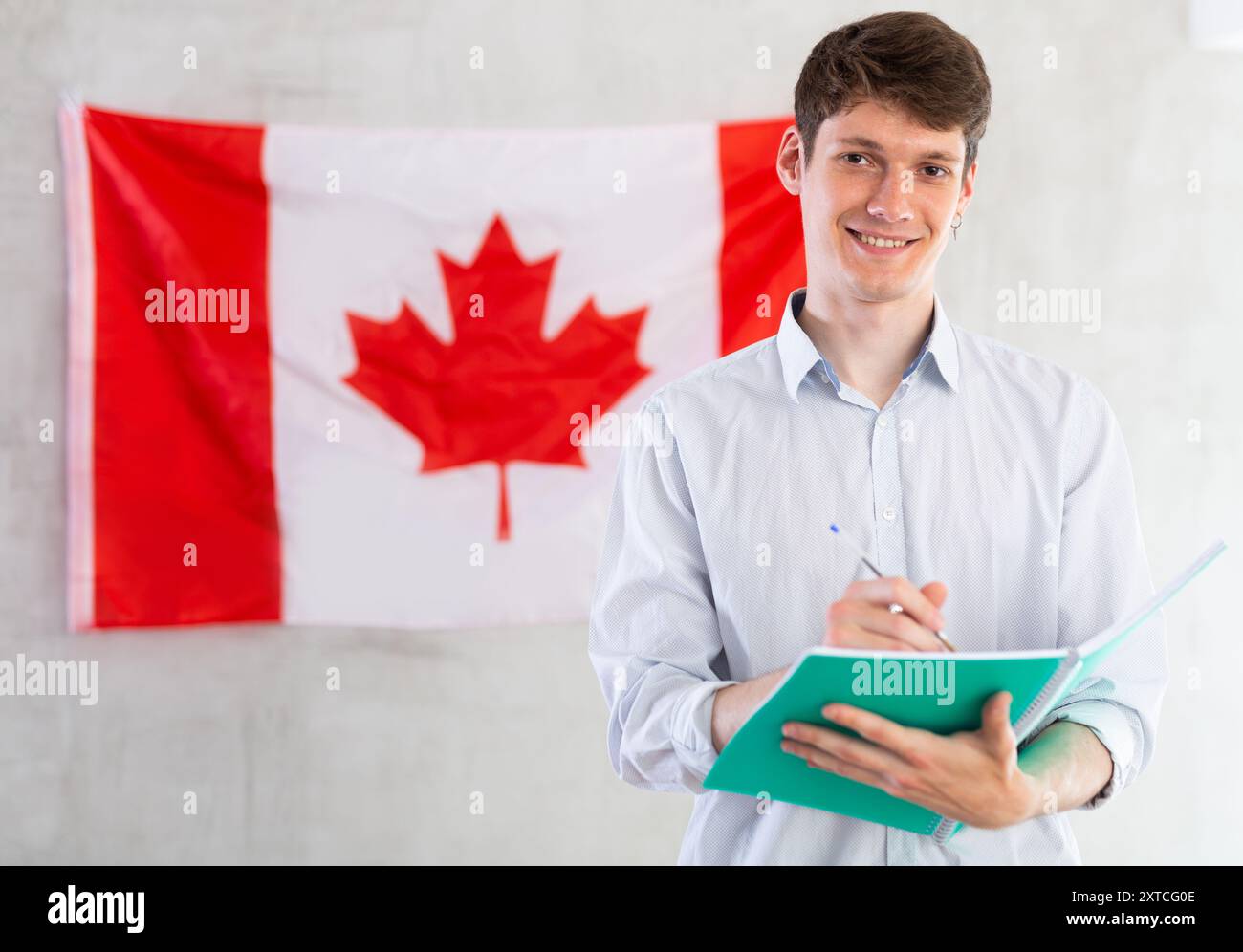 Der Junge macht Notizen vor dem Hintergrund der kanadischen Flagge Stockfoto