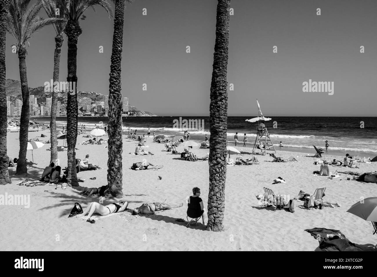 Urlauber liegen in der Sonne am Levante Beach in Benidorm, Provinz Alicante, Spanien Stockfoto