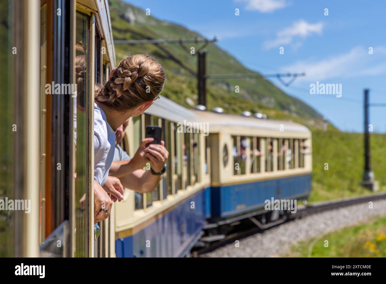 Zugpassagiere mit dem Alpine Classic Pullman Express am Oberalp-Pass in 2.000 Metern Höhe machen Fotos von der Kutsche auf der nostalgischen Fahrt von Davos nach Andermatt. Alpine Classic Pullman Express auf der Route des Glacier Express, URI, Schweiz Stockfoto