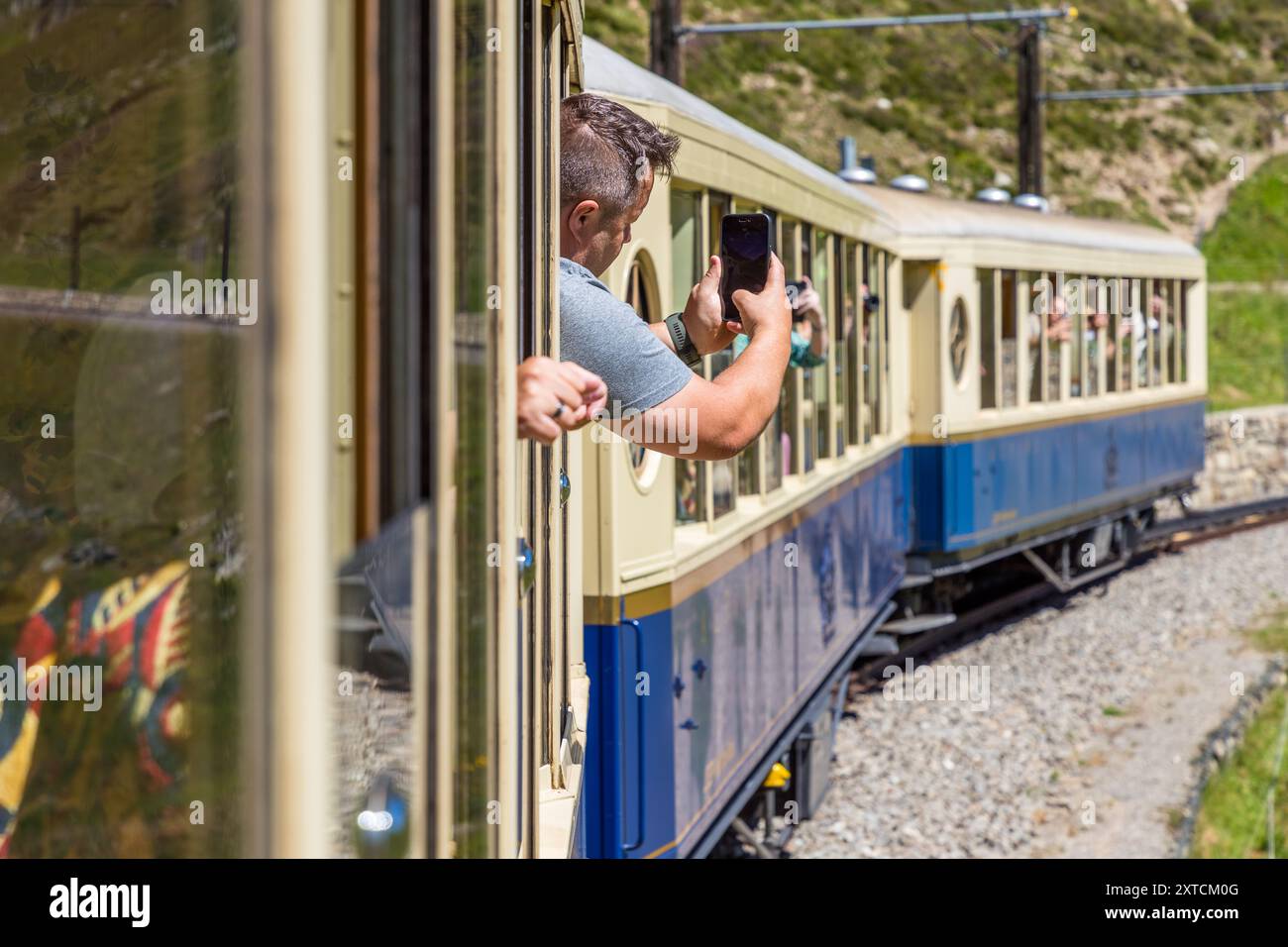 Zugpassagiere mit dem Alpine Classic Pullman Express am Oberalp-Pass in 2.000 Metern Höhe machen Fotos von der Kutsche auf der nostalgischen Fahrt von Davos nach Andermatt. Alpine Classic Pullman Express auf der Route des Glacier Express, URI, Schweiz Stockfoto