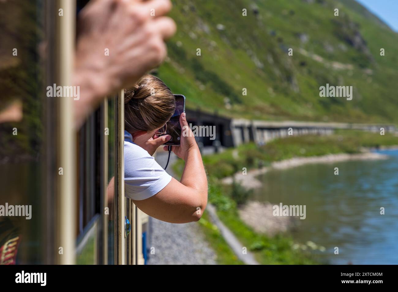 Zugpassagiere mit dem Alpine Classic Pullman Express am Oberalp-Pass in 2.000 Metern Höhe machen Fotos aus der Kutsche. Alpine Classic Pullman Express auf der Route des Glacier Express, URI, Schweiz Stockfoto