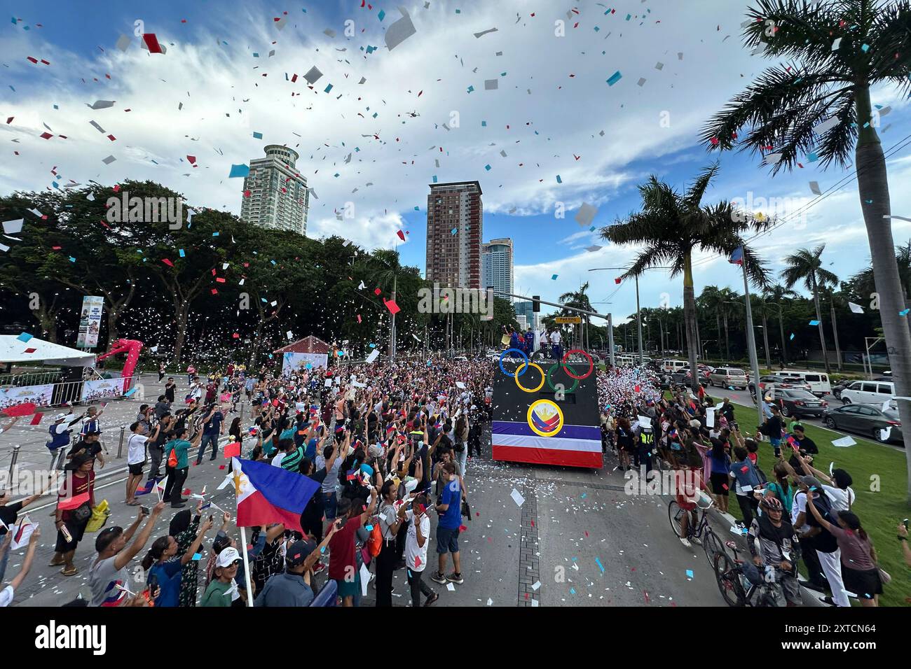 Filipinos cheer the motorcade honoring members of the Philippine