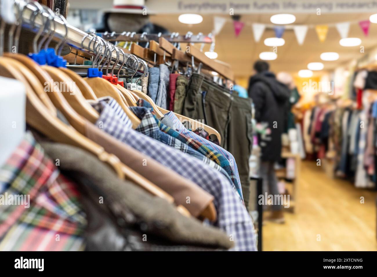 Kleidung in einem Wohltätigkeitsgeschäft in Großbritannien erhältlich. Stockfoto