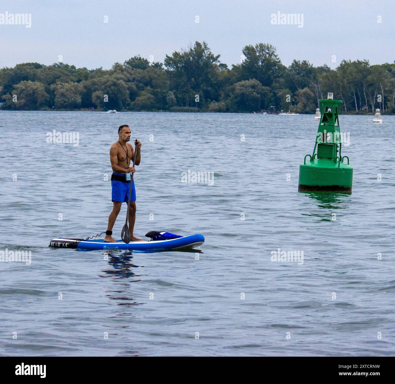 Man Paddleboarding auf dem Ontario-See im Hafen von Toronto mit Centre Island im Hintergrund Stockfoto