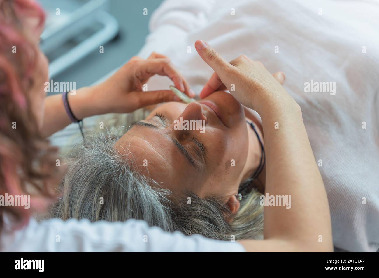 Ältere Frau, die eine Gesichtspflege erhält Stockfoto