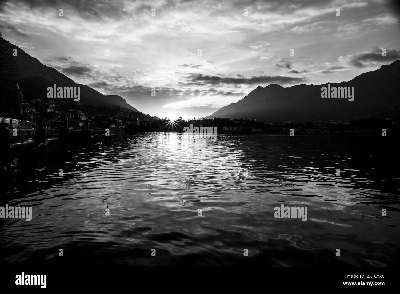 Blick auf den See Lecco im Herbst mit dem ruhigen und ruhigen Wasser an einem Abend mit Sonnenuntergang zwischen den Bergen in Lecco in Italien Stockfoto