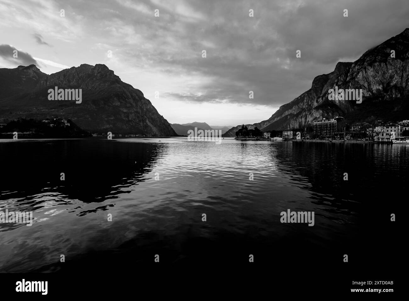 Blick auf den See Lecco im Herbst mit dem ruhigen und ruhigen Wasser an einem Abend mit Sonnenuntergang zwischen den Bergen in Lecco in Italien Stockfoto