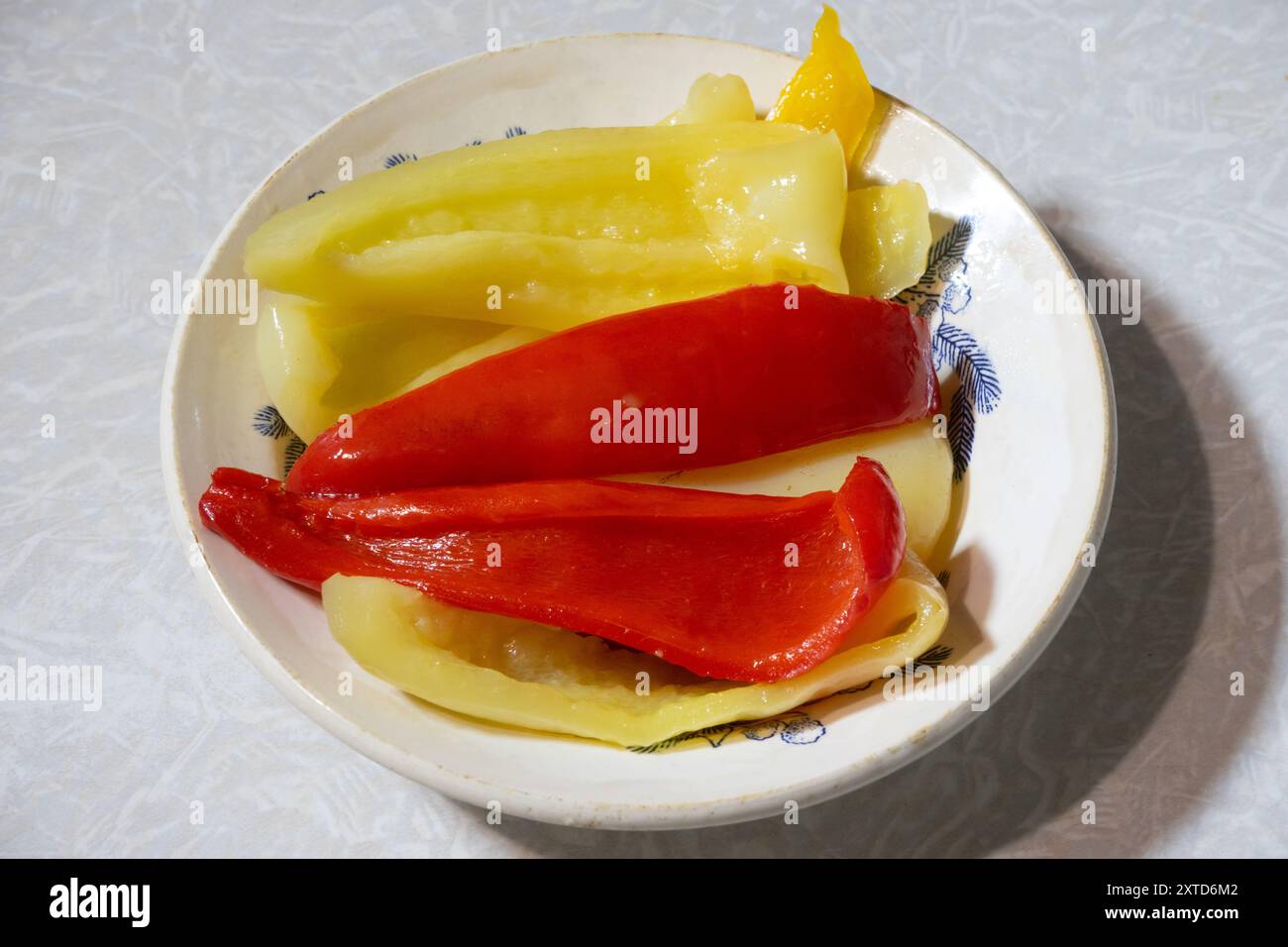 Gehackte gelbe und rote Paprika auf einem Teller. Stockfoto