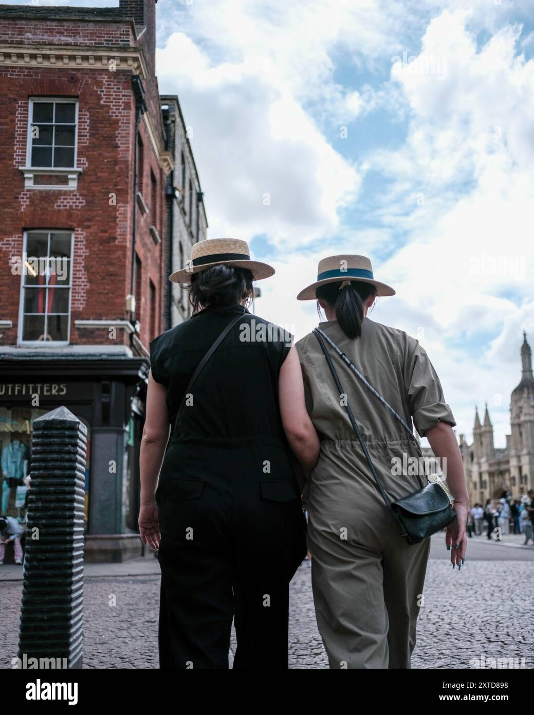 Touristen in Cambridge, Großbritannien, die einen Spaziergang machen und traditionelle Strohhüte tragen, die häufig beim Punting auf der River Cam getragen werden. Stockfoto