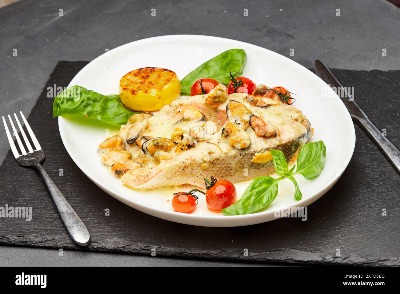 Köstliches gebackenes Lachssteak mit Sahnesauce und Muscheln wird auf einem Teller serviert und verzehrfertig serviert Stockfoto