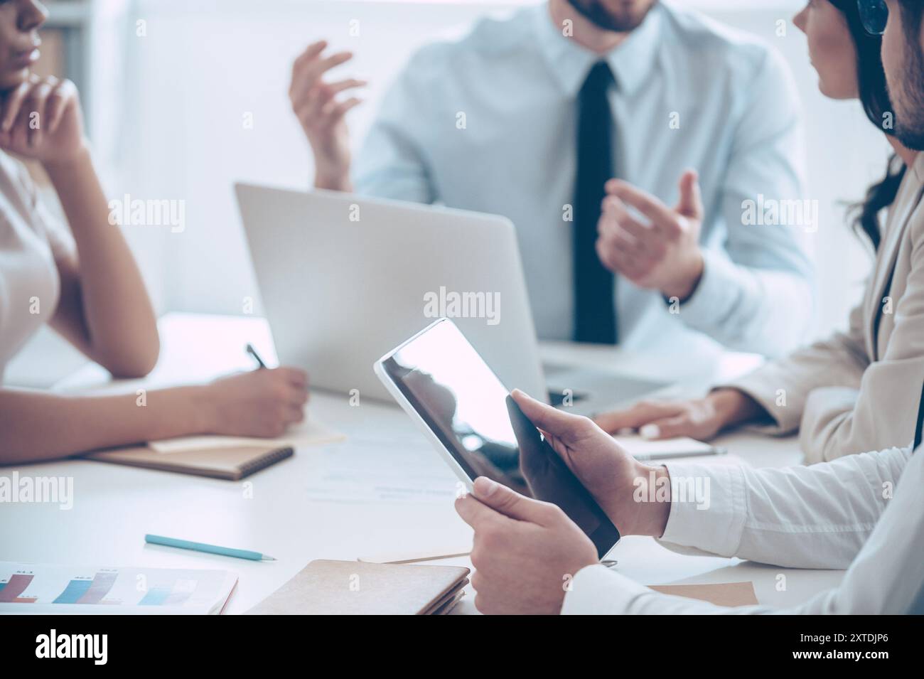 Brainstorming. Nahaufnahme eines Teils einer Gruppe von Leuten, die etwas besprechen, während sie am Bürotisch sitzen Stockfoto