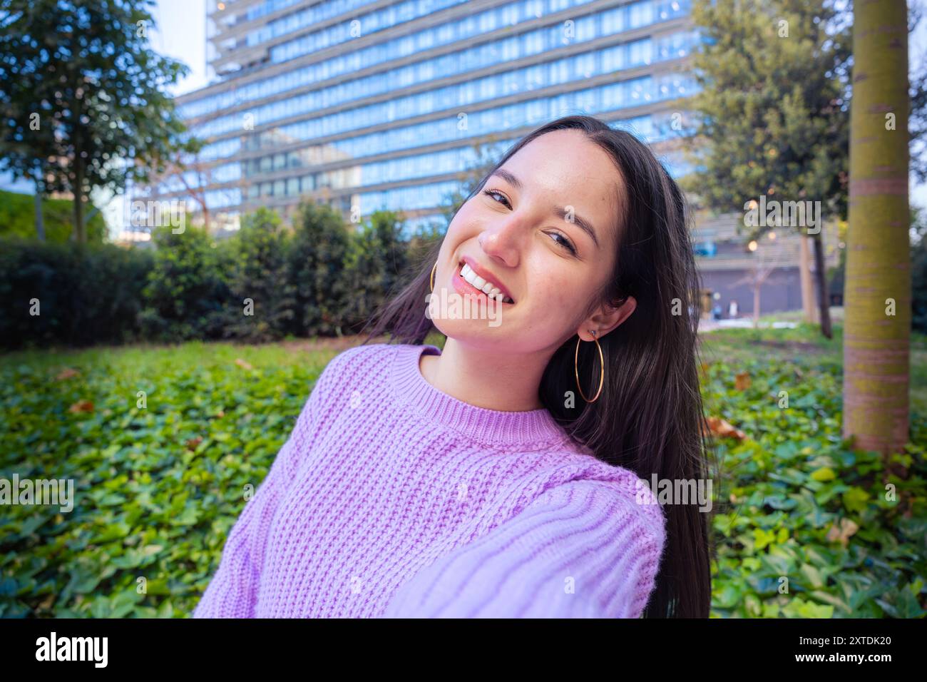 Junge lateinfrau, die selbstbewusst lächelnd auf der Straße steht Stockfoto