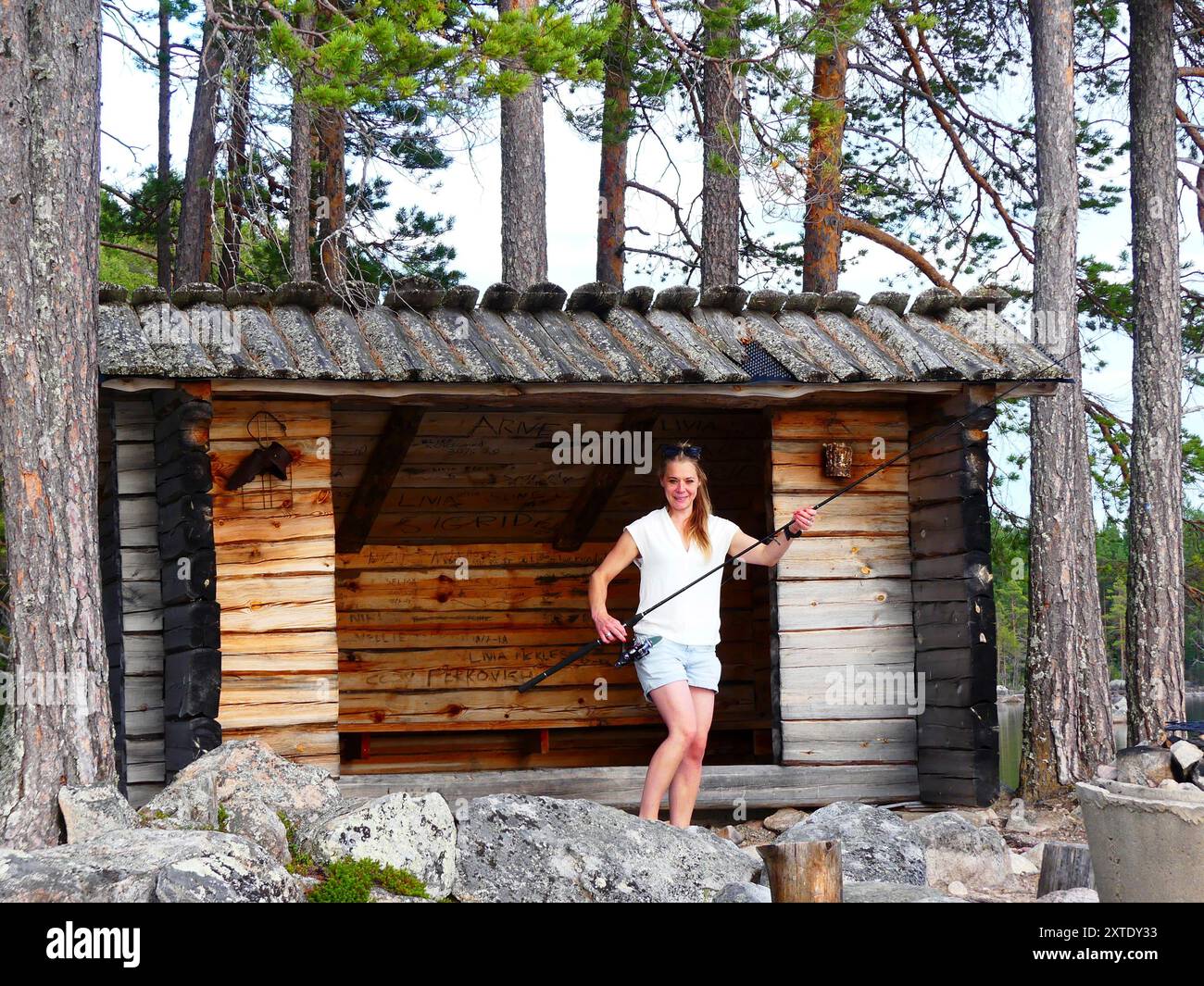 Lächelnde Frau mit Angelrute Stockfoto