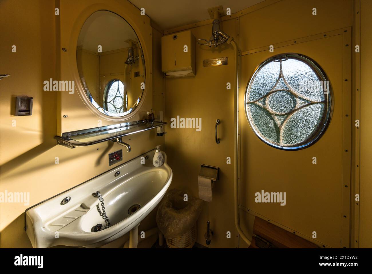 Zugtoilette im Alpine Classic Pullman Express, Baujahr 1931, mit Waschbecken aus Porzellan und Bullaugenfenster. Waschraum im Alpine Classic Pullman Express auf der Route des Glacier Express, Graubünden, Schweiz Stockfoto