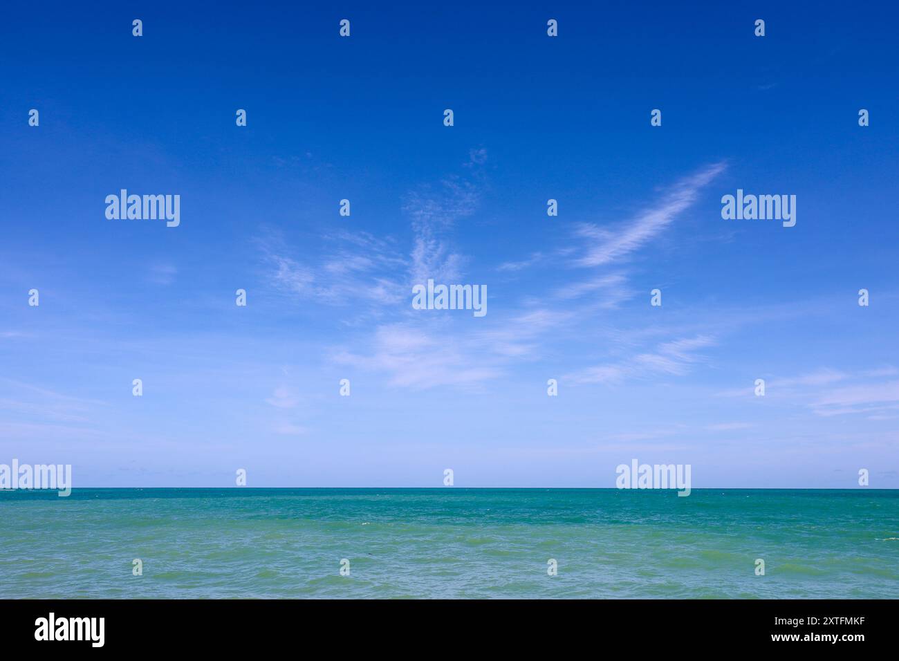 Leerer Strand, Blick auf azurblaue Wellen und blauen Himmel mit weißen Wolken. Tropische Küste, Hintergrund für Urlaub in einer paradiesischen Natur Stockfoto
