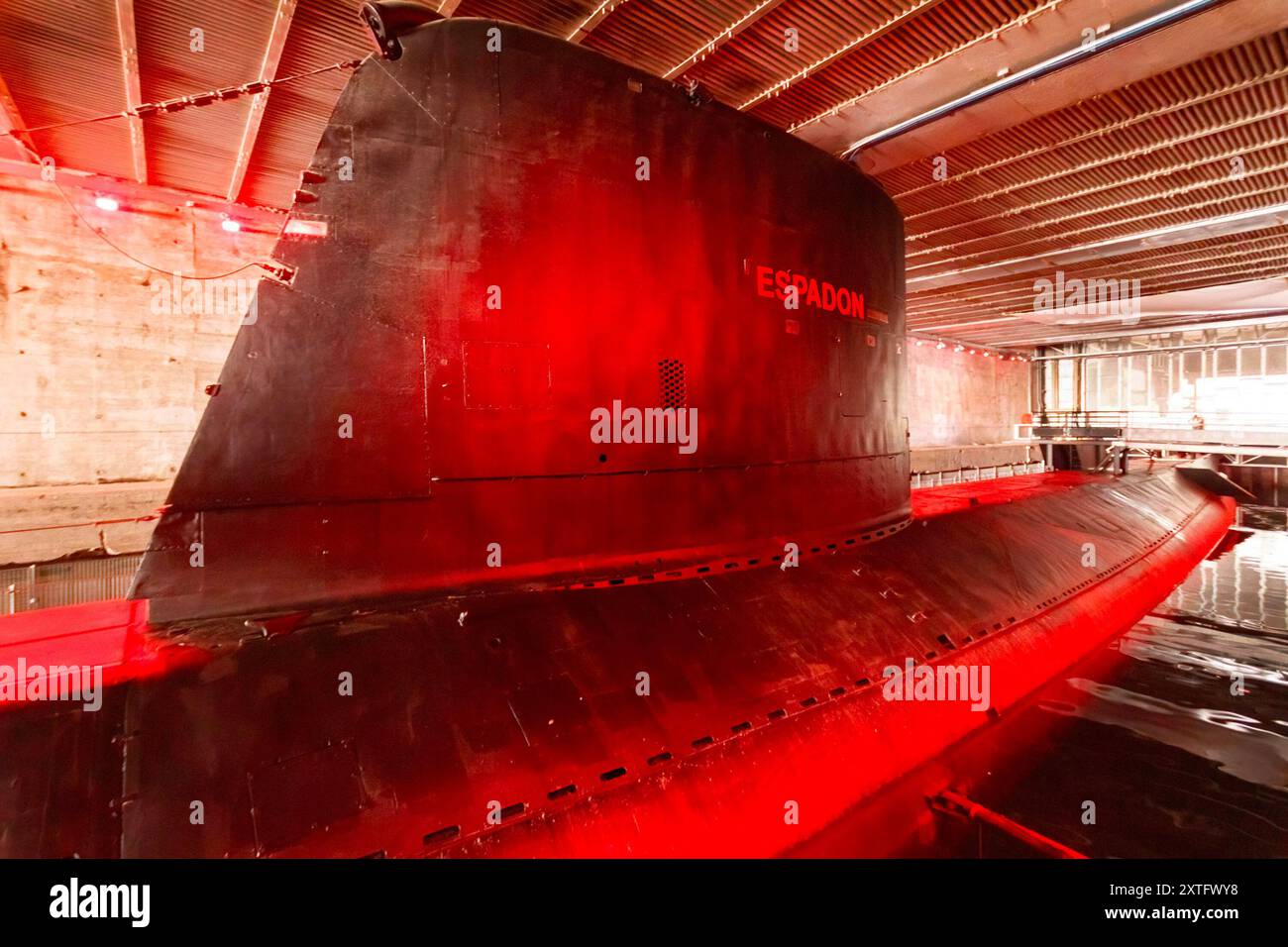Französisches U-Boot Espadon S637 im historischen U-Boot-Stall am Hafen von Saint-Nazaire in Frankreich mit roter Beleuchtung und Wasserreflexion Stockfoto