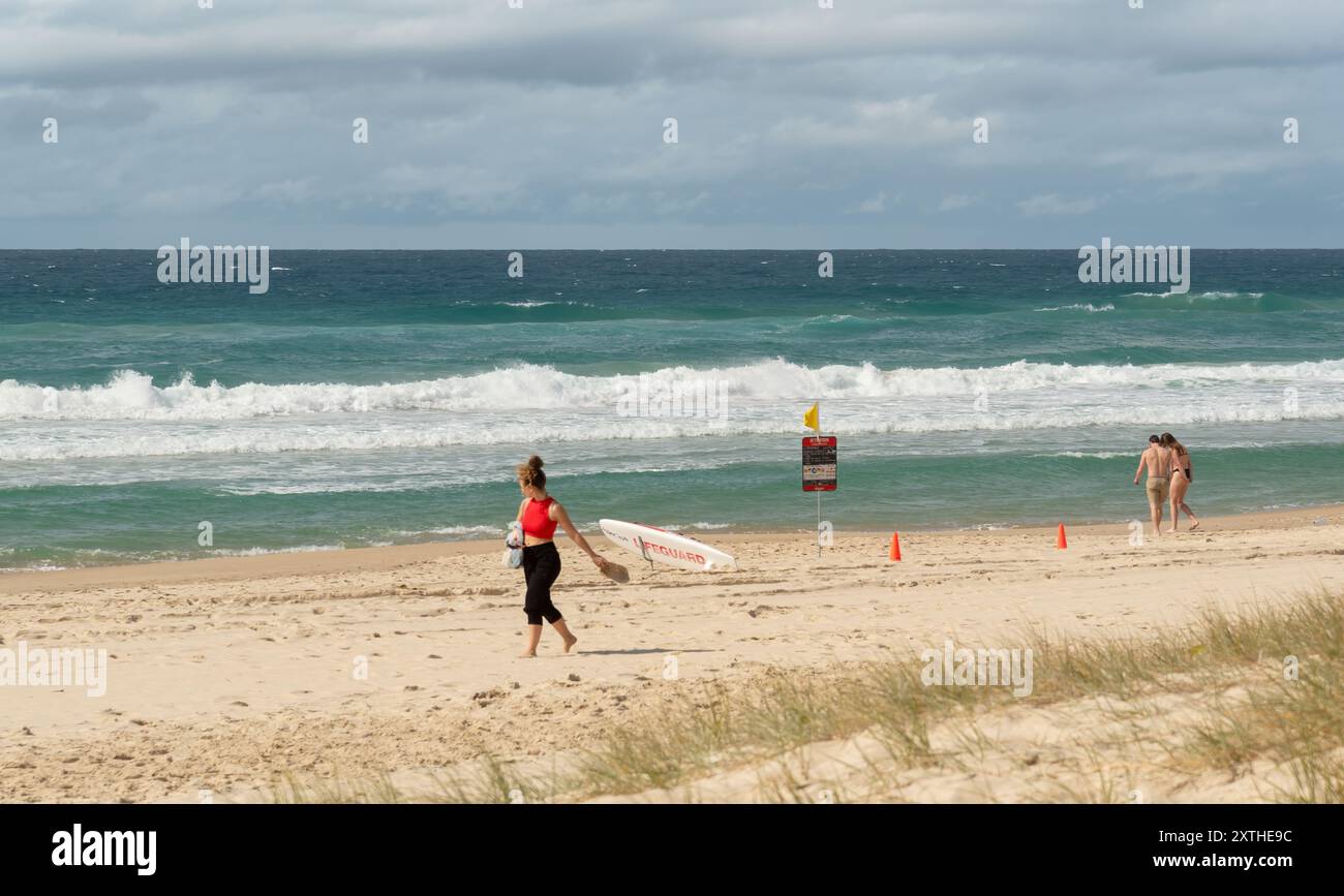 Nicht identifizierte Personen an einem Sandstrand mit Rettungsschwimmern in Surfers Paradise, Queensland, Australien, 11. August 2024. Stockfoto