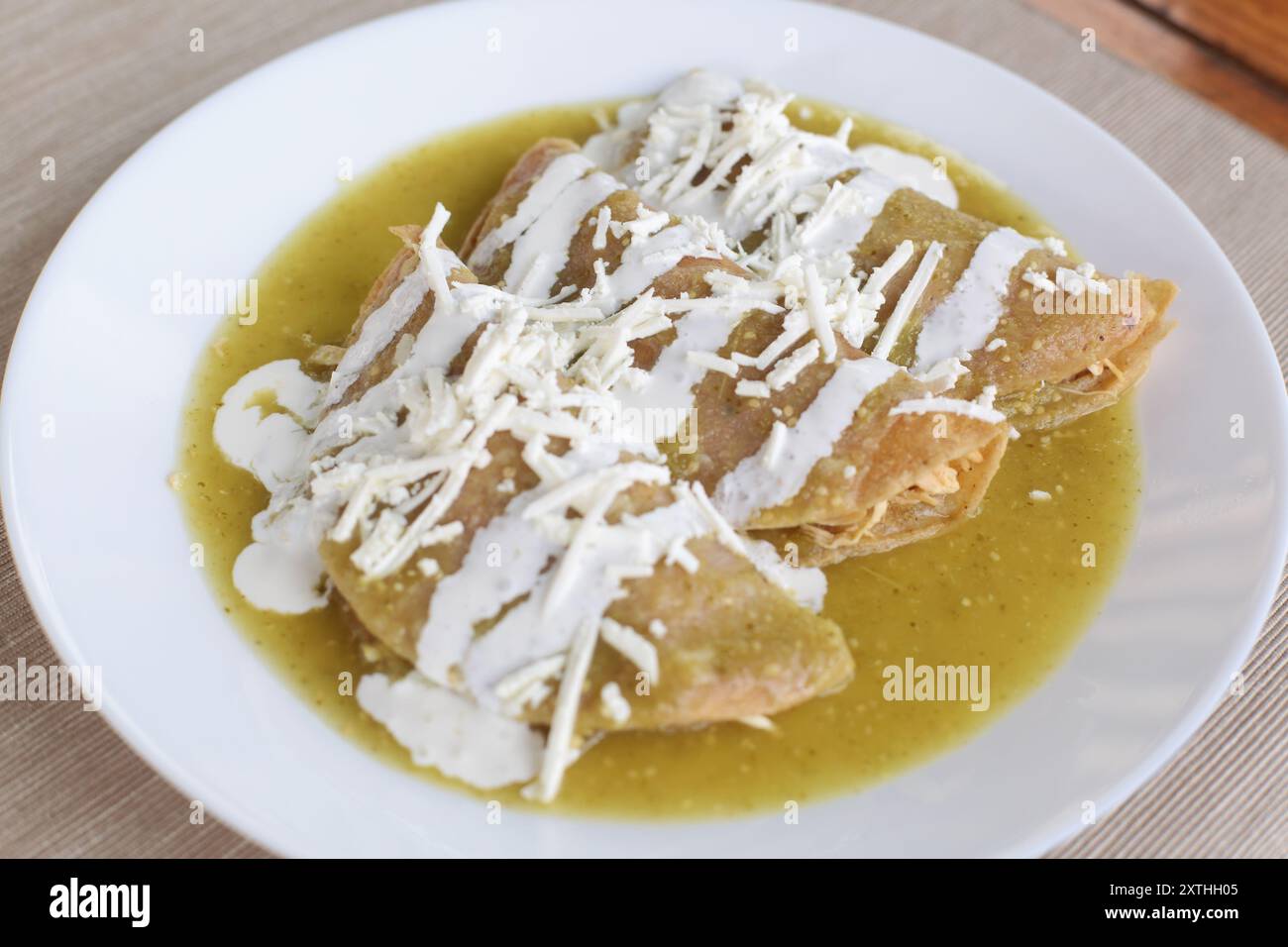 Typische grüne Enchiladas mit Huhn, Sahne und Käse Stockfoto
