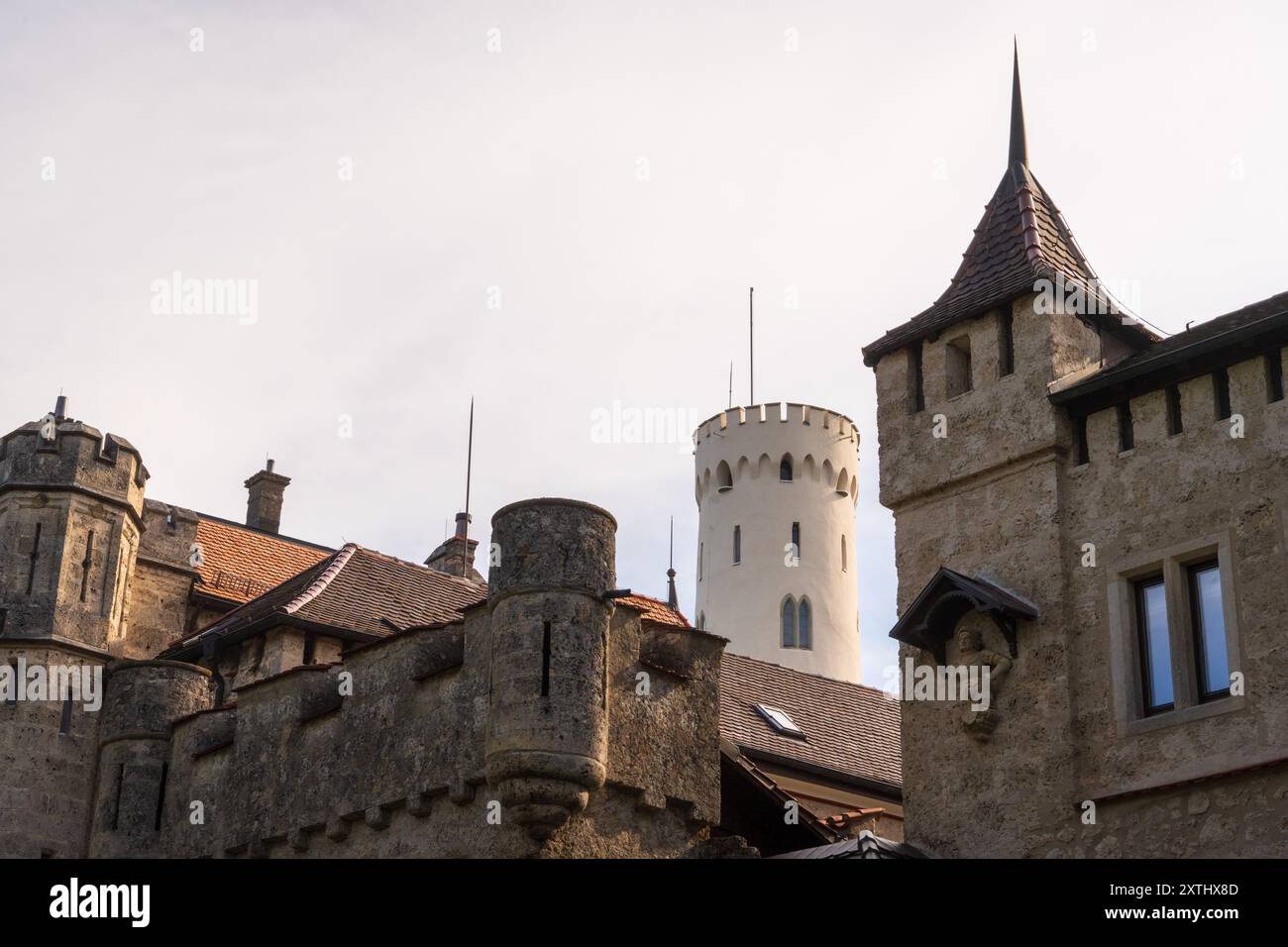 Die Gruppe von Steintürmen und spitzen Türmchen der Burg Lichtenstein erhebt sich vor einem bewölkten Himmel. Stockfoto