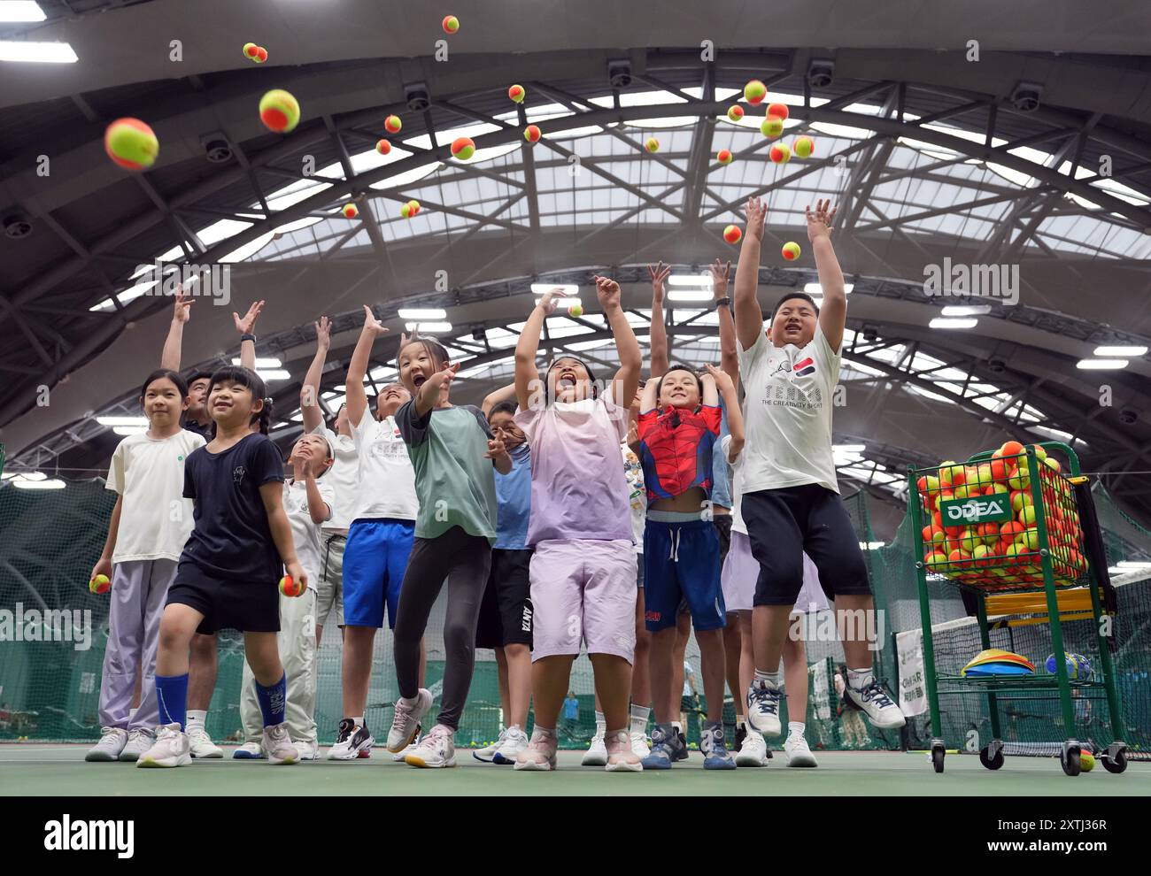 (240815) -- PEKING, 15. August 2024 (Xinhua) -- Kinder, die Schüler feiern, nachdem sie an einem Tennis-Sommercamp in einem Tennisclub in Peking, China, teilgenommen haben, 14. August 2024 China hat kürzlich einen Anstieg der Tennisbegeisterung erlebt, was sich in einem bemerkenswerten Anstieg der Nachfrage nach Trainingskursen und Platzreservierungen in verschiedenen Städten zeigt. Dieser Anstieg kann dem historischen Sieg des chinesischen Tennisspielers Zheng Qinwen zugeschrieben werden, der bei den Olympischen Spielen in Paris die erste Goldmedaille im Tennis gewann. Es ist erwähnenswert, dass nicht nur mehr Erwachsene Tennis als Erholunga nehmen Stockfoto