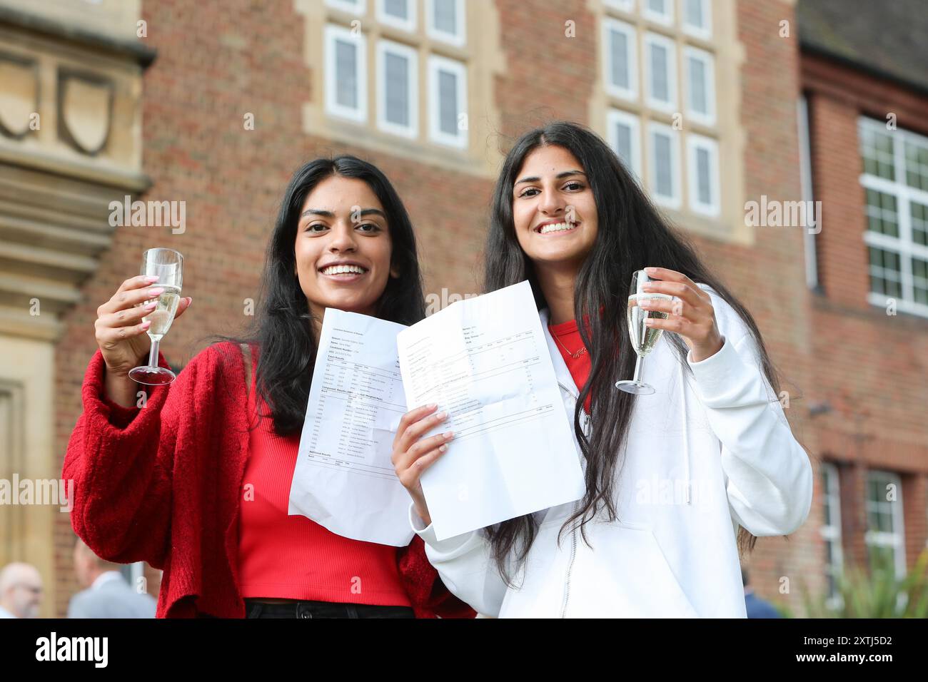 Birmingham, Großbritannien. August 2024. Die Schüler Sana Sibal (4 Sterne) und Avni Cheema (2 Sterne und 1 Klasse A) feiern mit einem frühen Glas Prosecco an der King Edward VI High School for Girls, einer unabhängigen Schule in Edgbaston, Birmingham. Sana wird Wirtschaftswissenschaften in Cambridge studieren, und Avni wird zur LSE gehen, um Umweltwissenschaften zu studieren. Quelle: Peter Lopeman/Alamy Live News Stockfoto