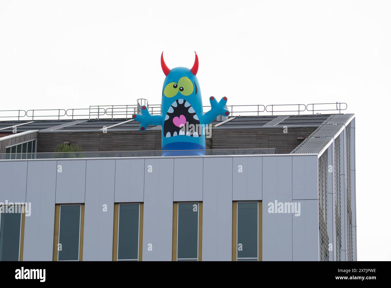 Slough, Großbritannien. August 2024. Das Stadtzentrum von Slough in Berkshire sah heute fröhlicher aus als sonst, als fünf riesige aufblasbare Dachmonster die Käufer und Besucher des Stadtzentrums begrüßten. Die Künstler Luke Egan und Peter Hamilton haben die riesigen aufblasbaren Monster auf dem Porter Building, dem Queensmere Shopping Centre, The Future Works, Aston Bond Solicitors und dem Brickhouse installiert. Monster Nosey Bonk, Bezerker, Tentakel, Brülzer und eine Familie von Goofs erweisen sich in den Schulferien als großer Hit bei Kindern. Die Monster bleiben in dir Stockfoto