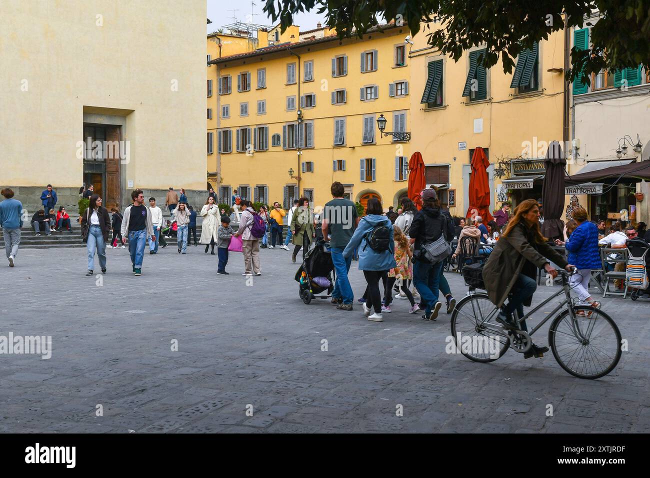 Eine Ecke der Piazza Santo Spirito in Oltrarno, mit Einheimischen und Touristen vor der Basilika Santo Spirito im Frühling, Florenz, Italien Stockfoto