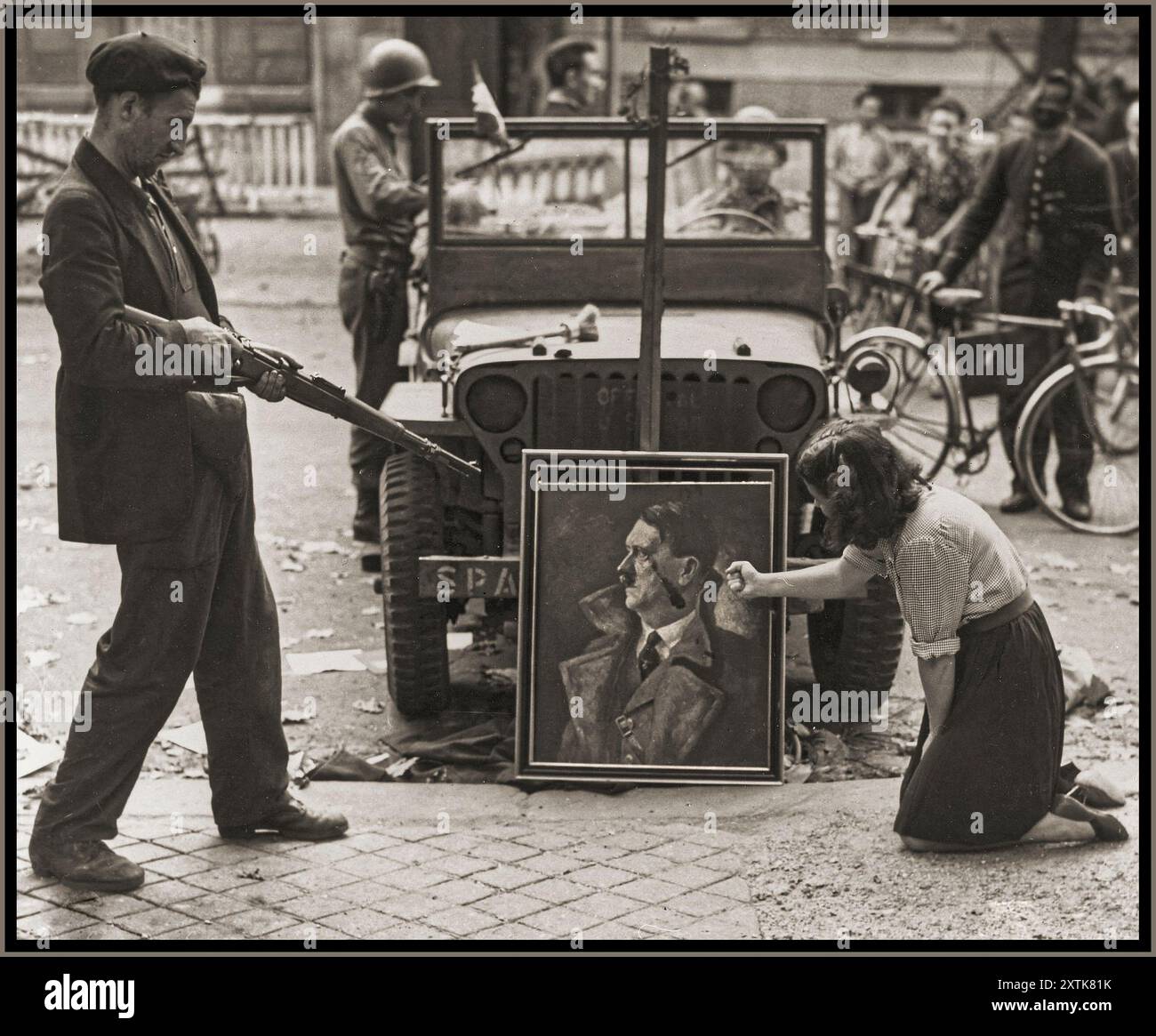 2. Weltkrieg FRANZÖSISCHER WIDERSTAND PARIS Ein französischer Zivilist und ein französischer Widerstandskämpfer vereiteln ein offizielles Nazi-Porträt von Adolf Hitler. August 1944 Paris, [Seine] Frankreich Stockfoto